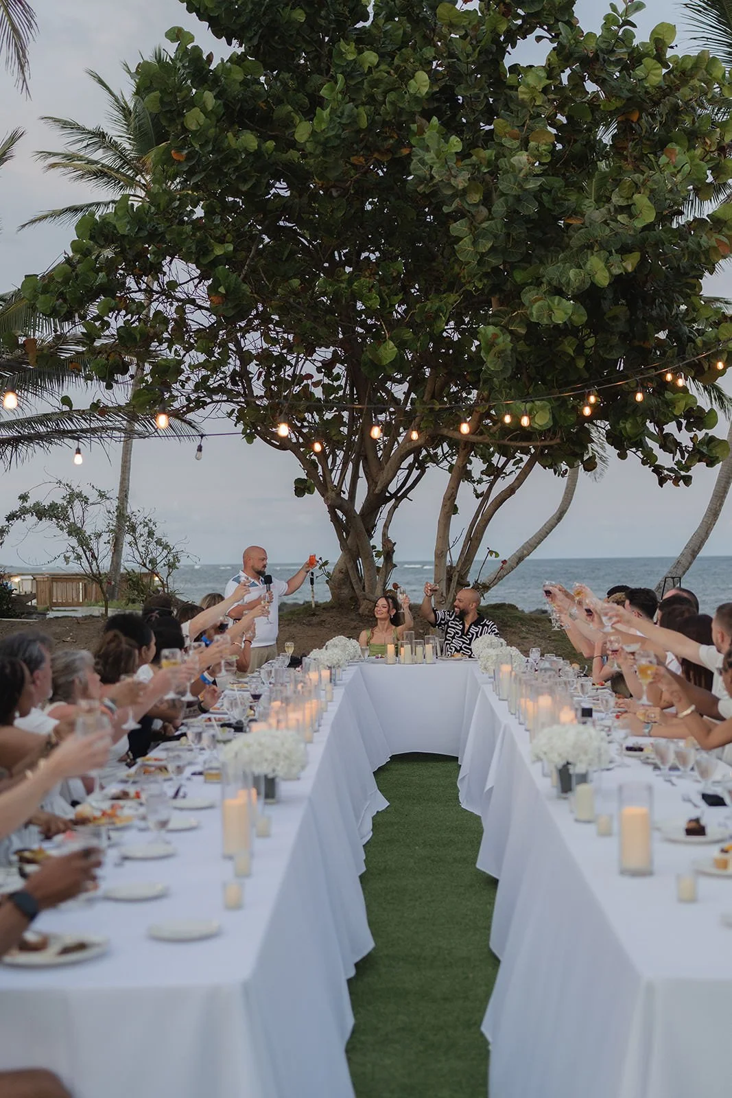 Wedding reception aisle lined with string lights under a tree, St. Lucia welcome dinner