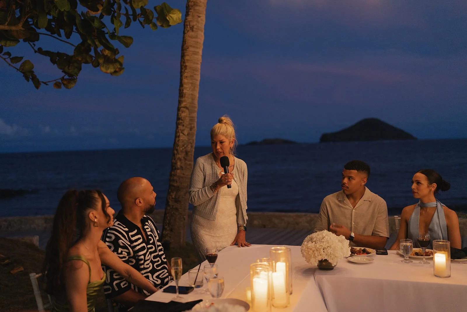 Wedding welcome dinner toast by candlelight on the beach at night, St. Lucia