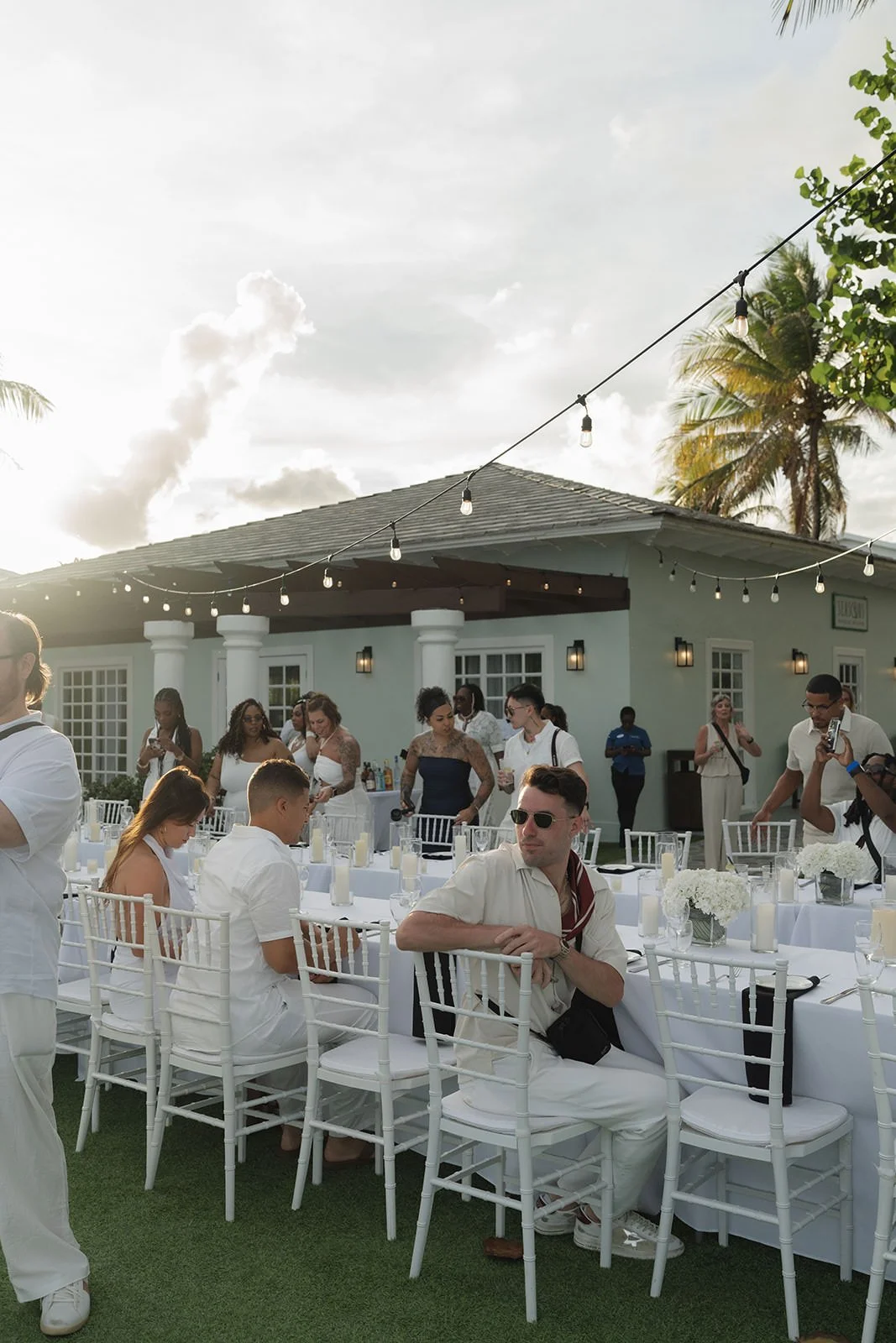 Guests seated under string lights outside a white resort building at the St. Lucia welcome dinner