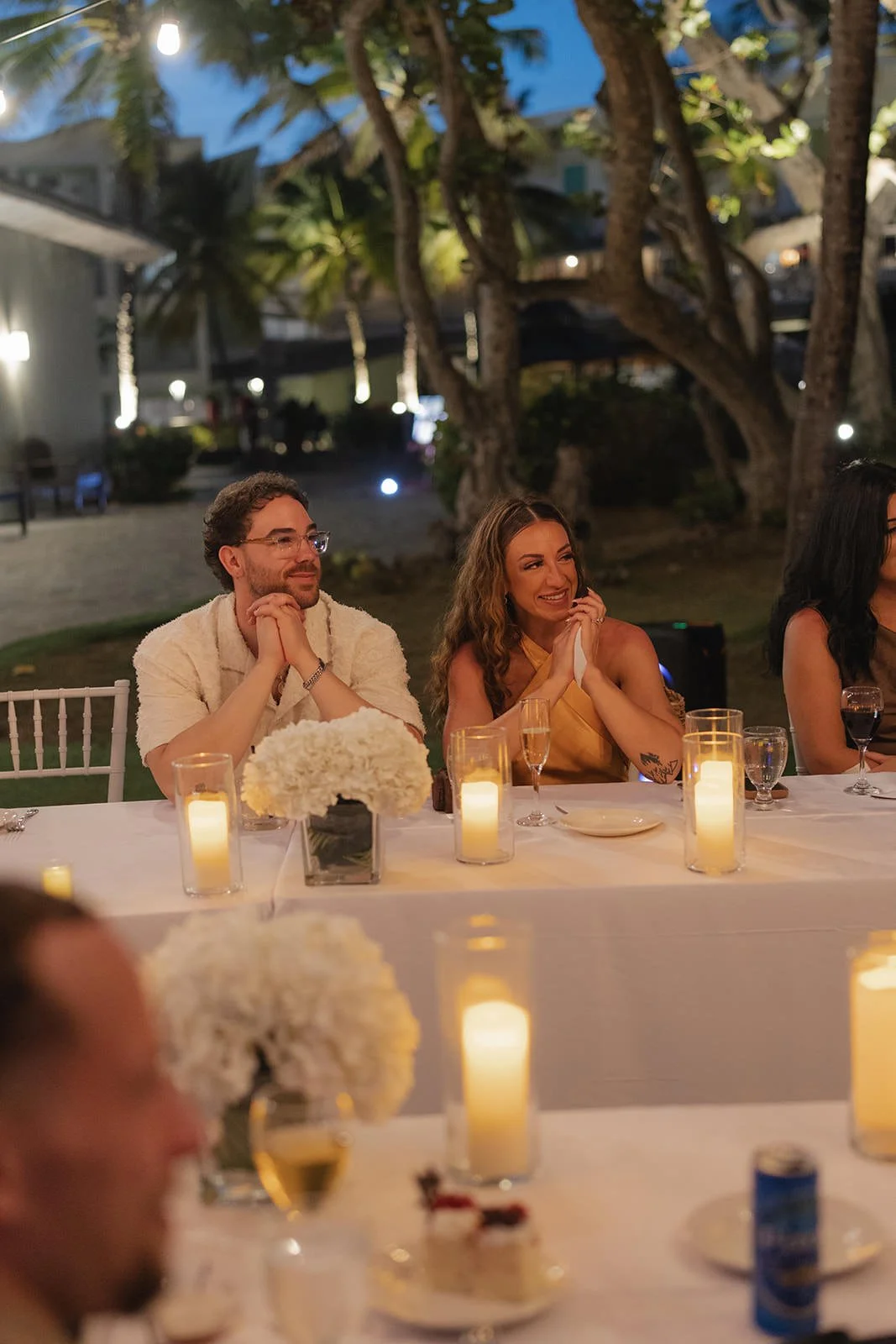 Guests laughing over candlelit dinner at the St. Lucia welcome dinner table