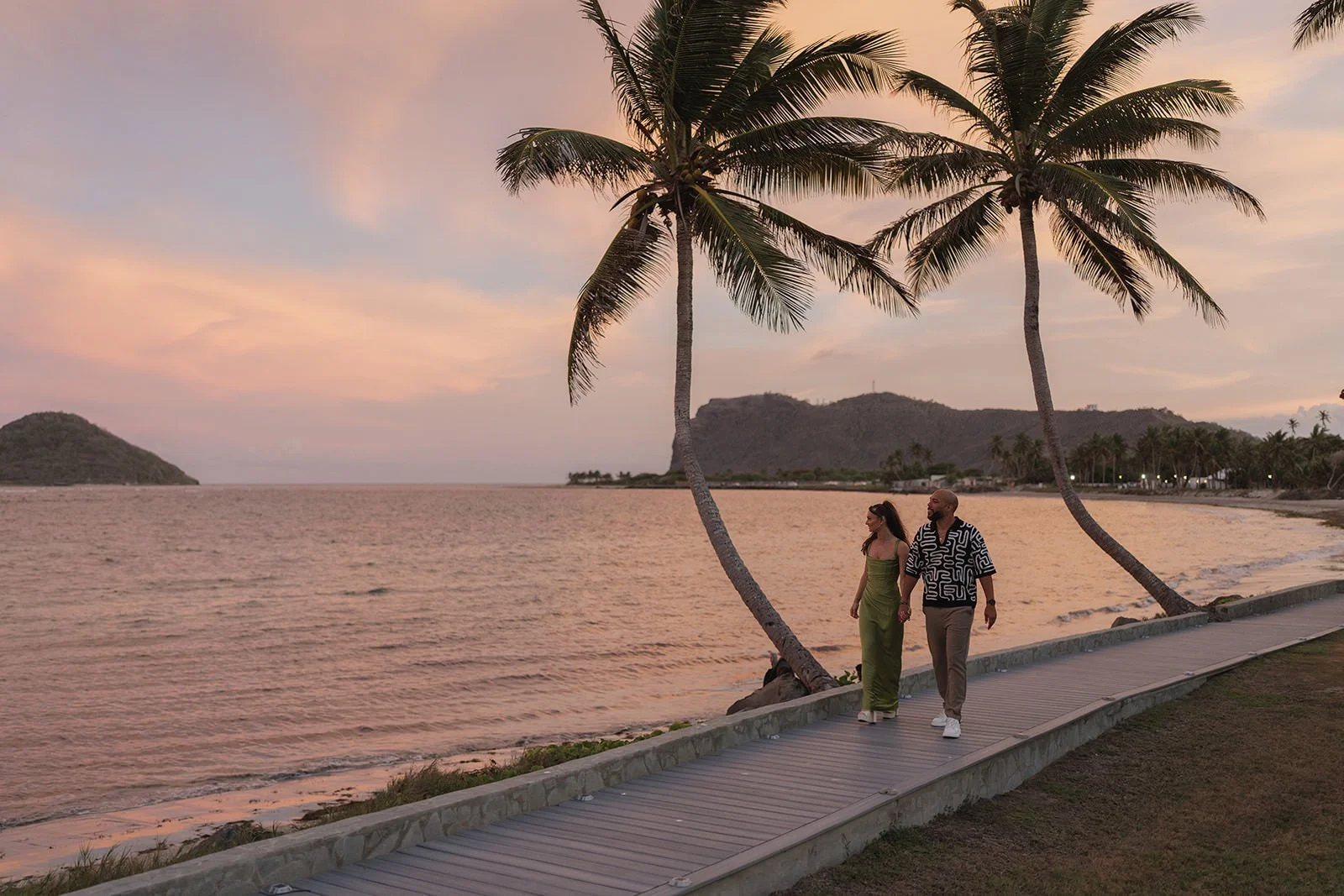 Bride and groom walking hand in hand along the beach at sunset in St. Lucia