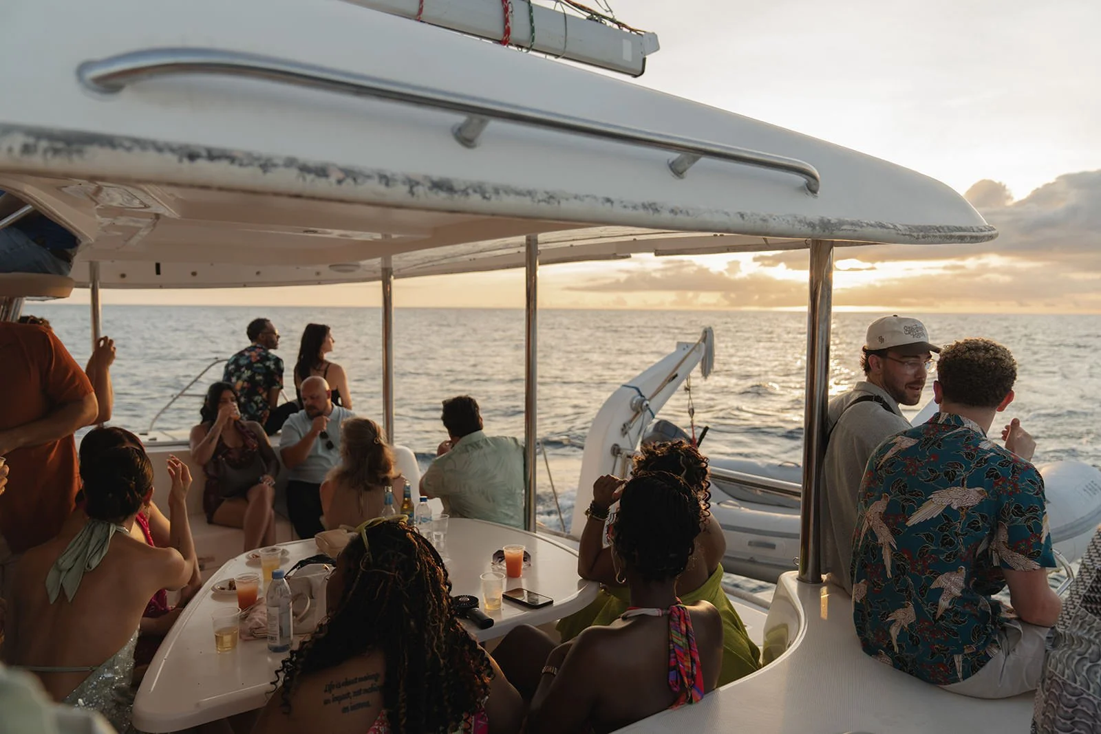 Wedding guests seated together under the catamaran's canopy, enjoying the sailing excursion during the wedding weekend in St. Lucia