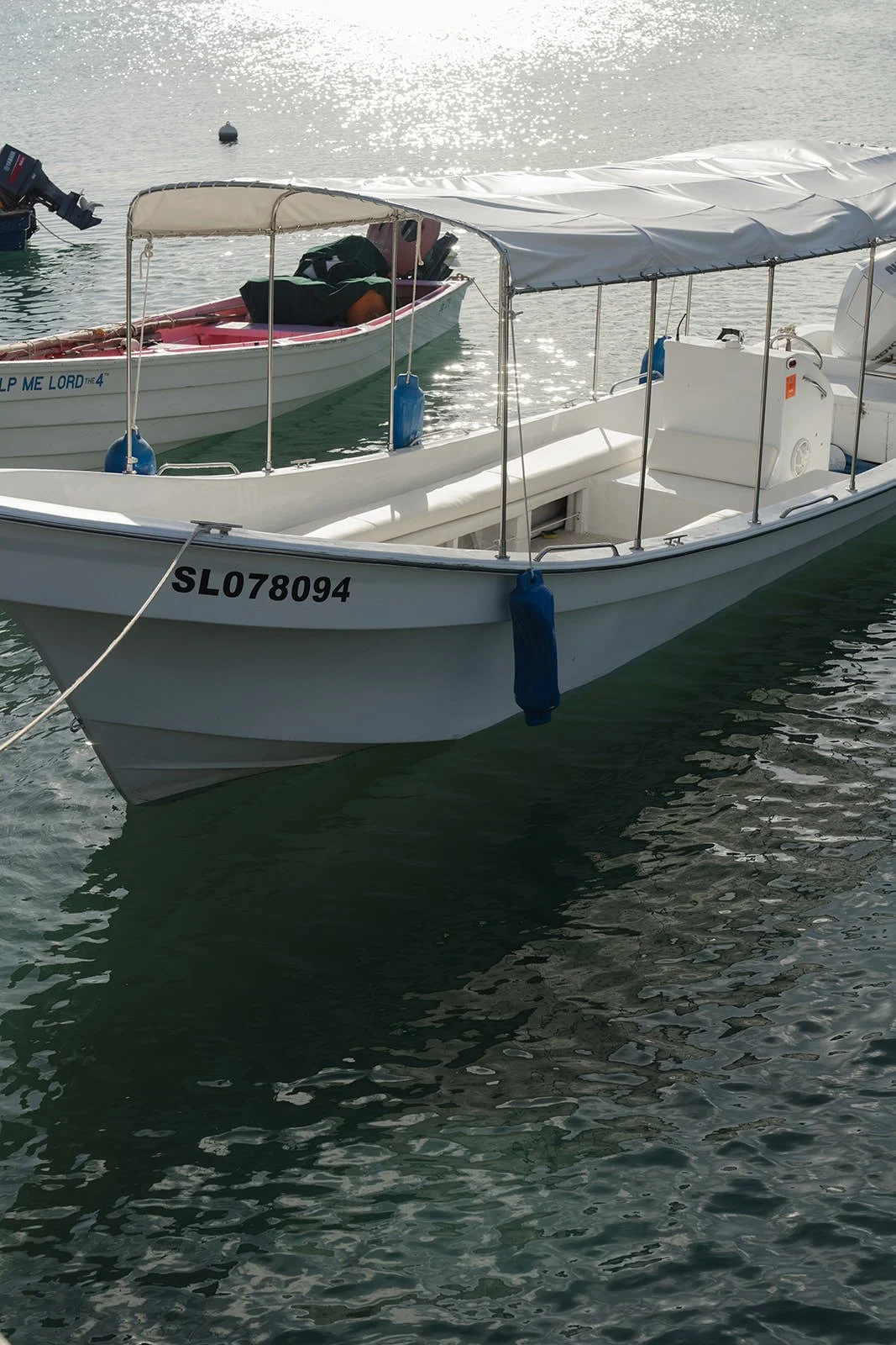 Small tender boat moored in the water off St. Lucia during the wedding weekend catamaran excursion