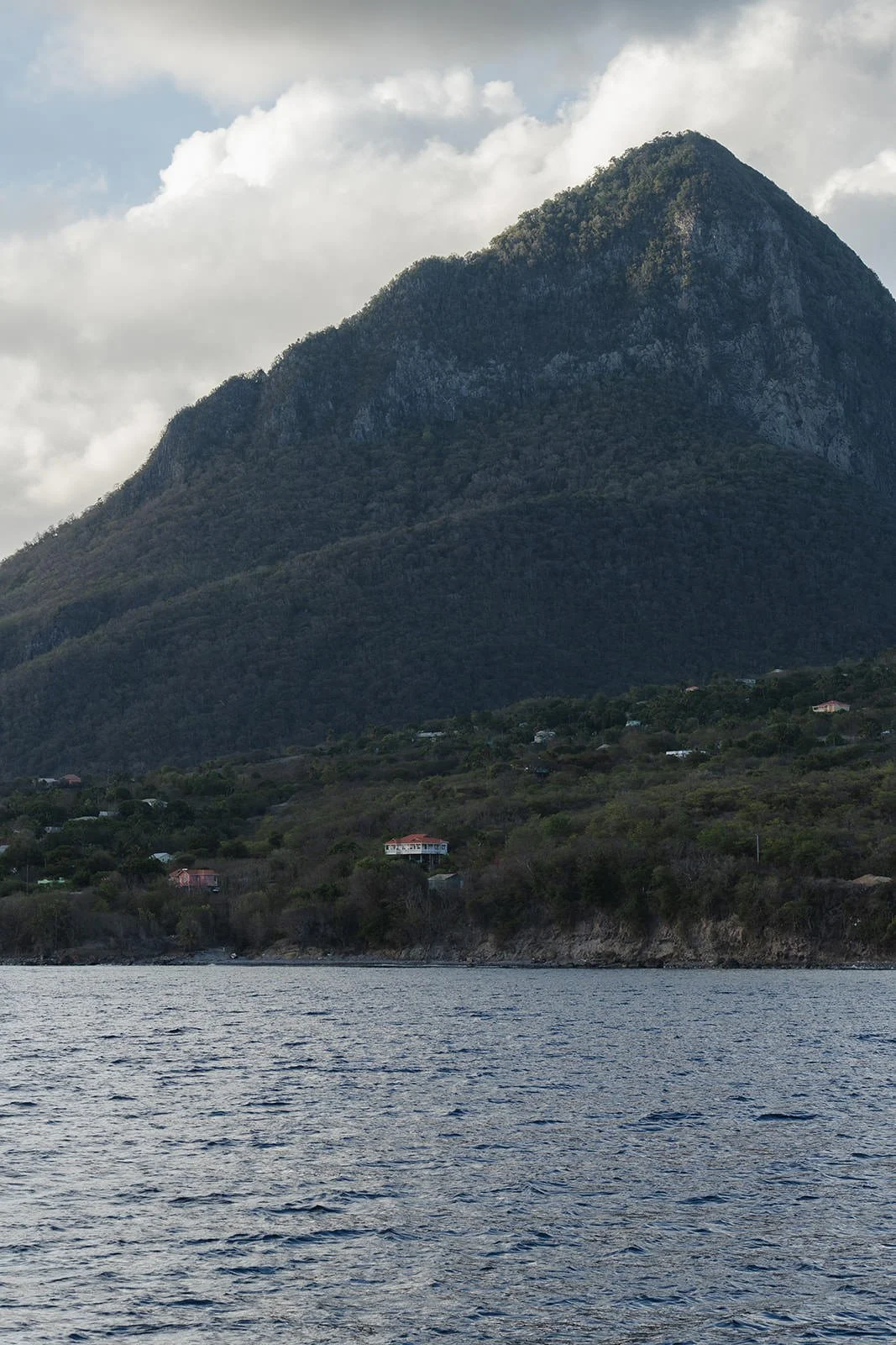 Dramatic view of one of St. Lucia's Piton mountain peaks rising above the coastline, seen from the water during the catamaran excursion