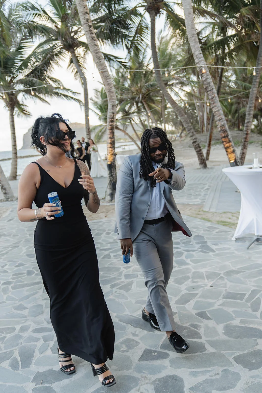 Wedding guest in a black dress standing on the St. Lucia beach at the wedding celebration