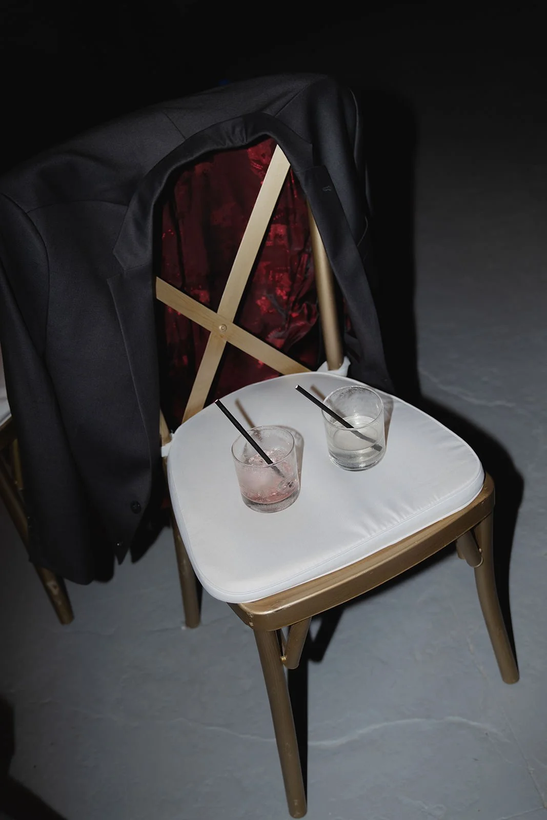 Decorated wedding chair with an X-back design and two wine glasses set on the seat, part of the St. Lucia beach ceremony decor