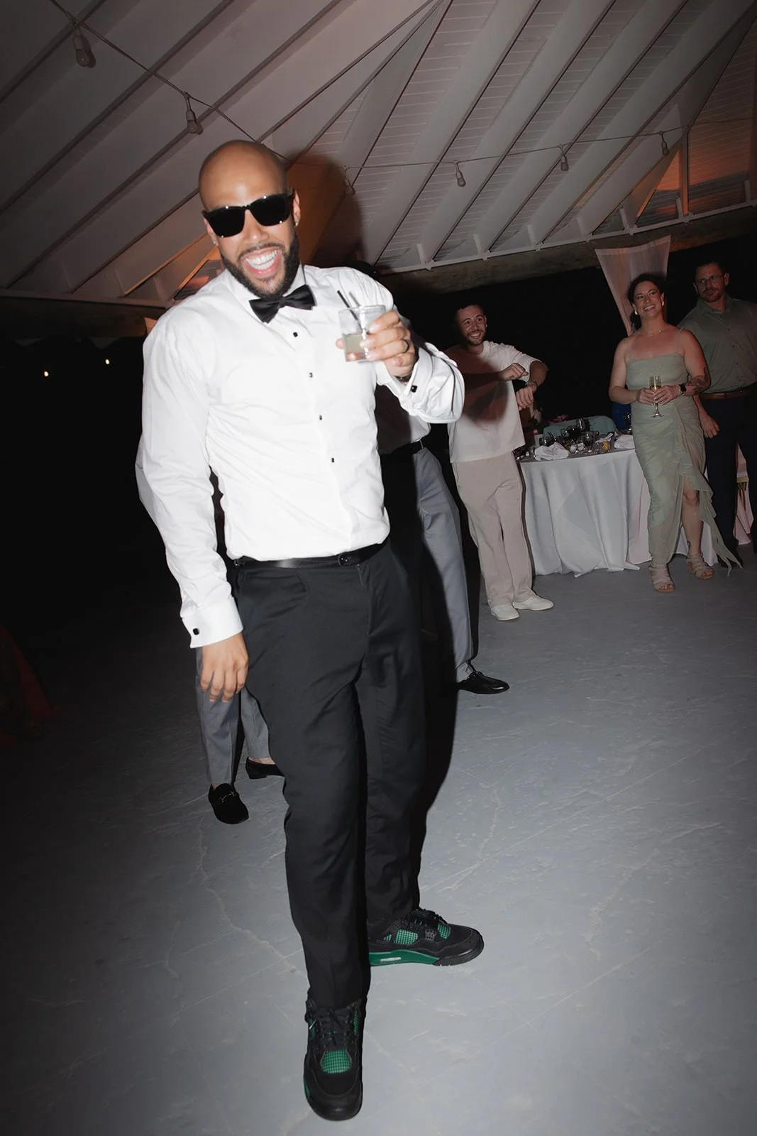 Wedding guest in a tuxedo dancing energetically on the reception dance floor in St. Lucia
