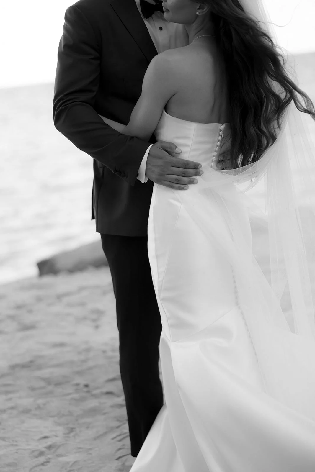 Black and white close-up of the bride and groom embracing on the St. Lucia beach