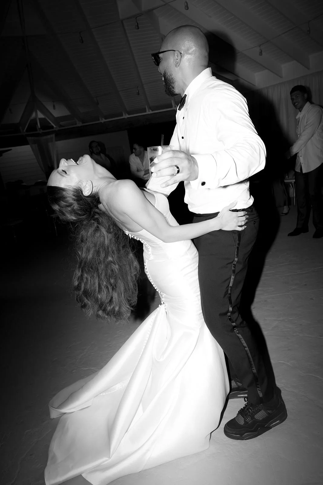 Black and white photo of the groom dipping the bride during a dance at the St. Lucia wedding reception