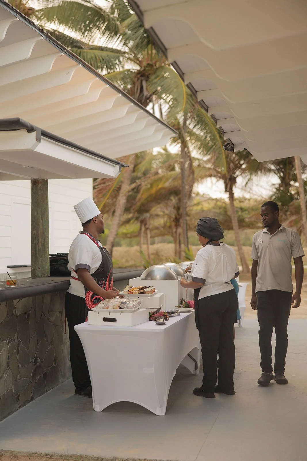 Chef and catering staff preparing a food station under a covered terrace at the St. Lucia wedding weekend