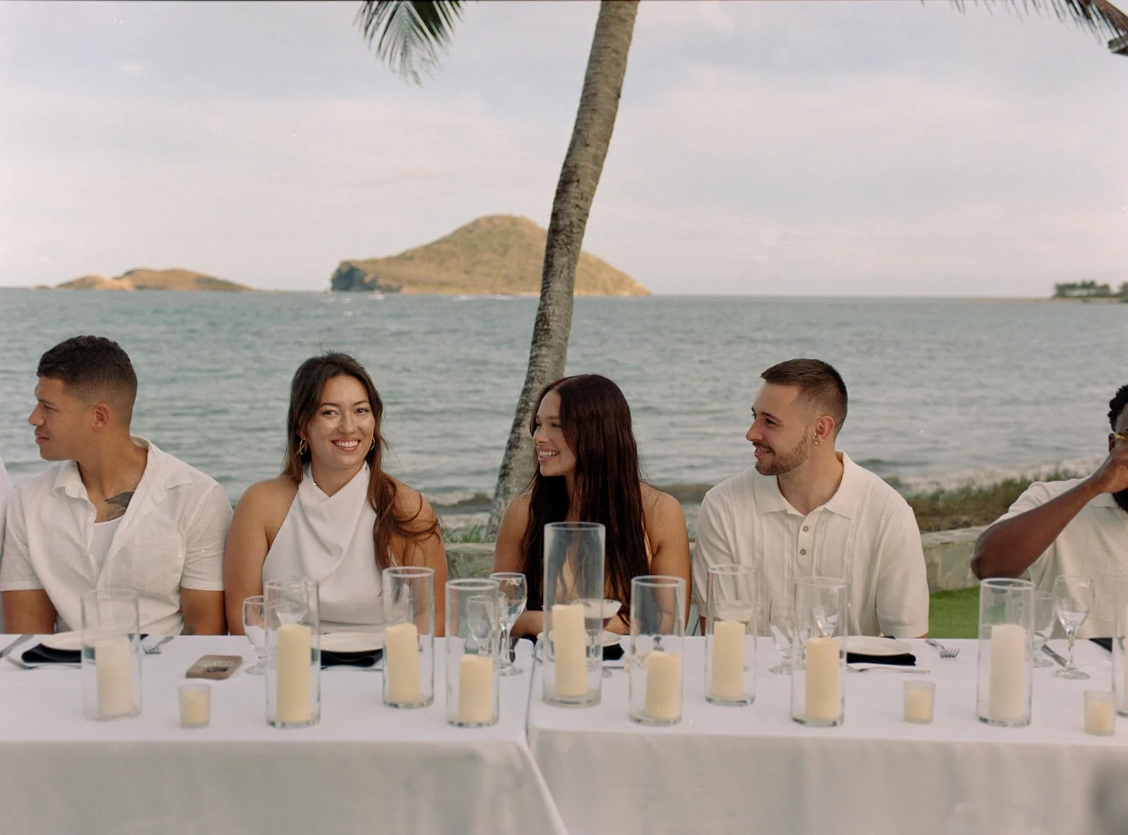 Wedding guests seated together at an outdoor table under palm trees in St. Lucia