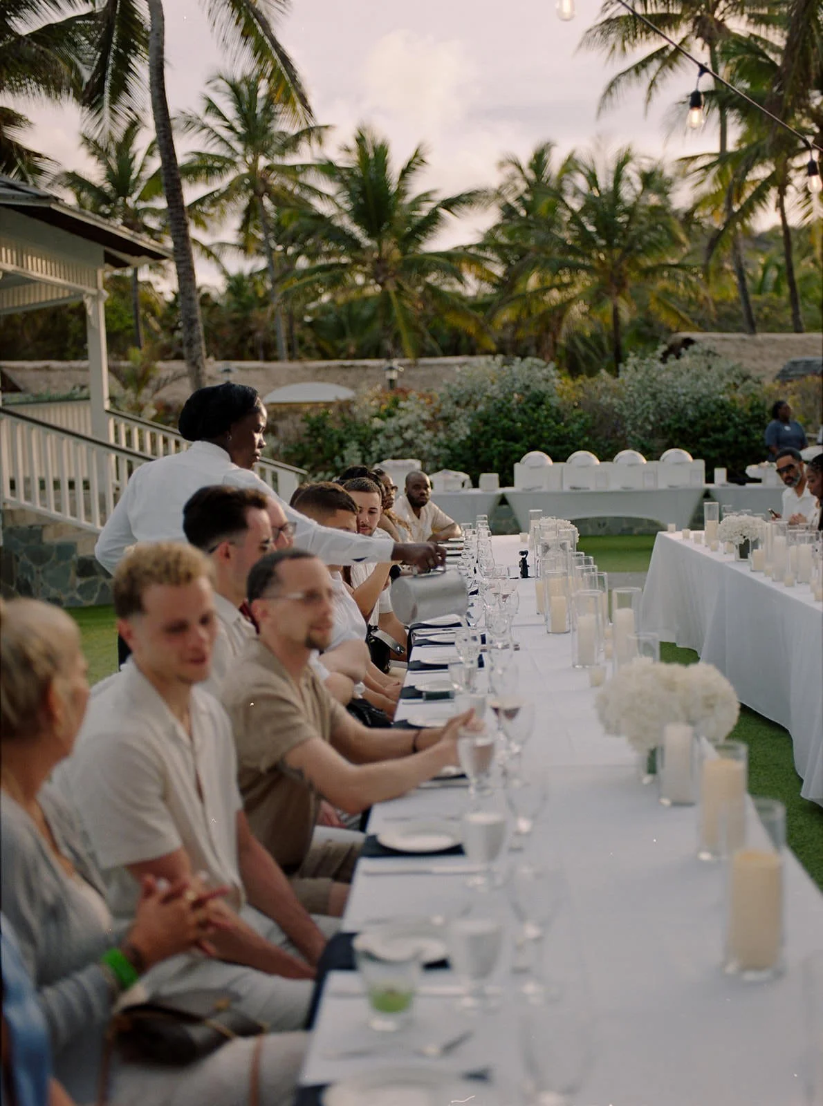 Guests seated at the long welcome dinner table surrounded by tropical greenery in St. Lucia