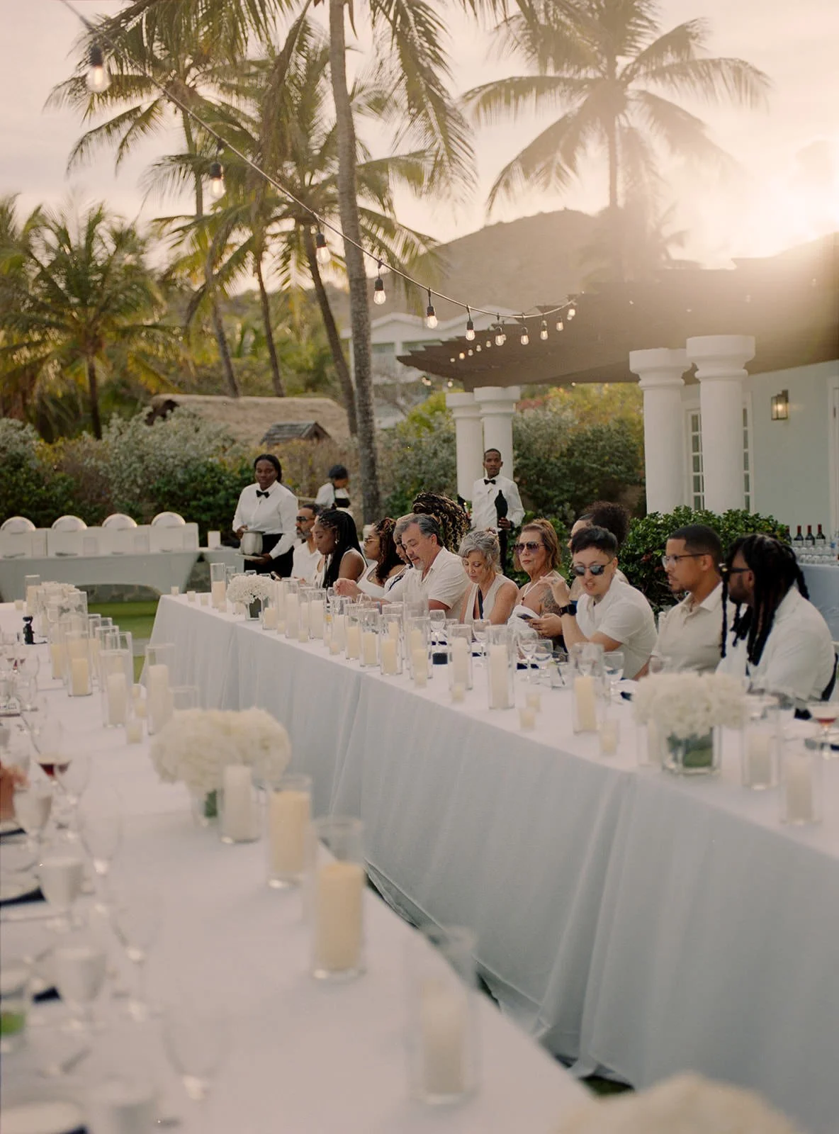 Long dinner table set at golden hour in front of the resort building, St. Lucia wedding weekend