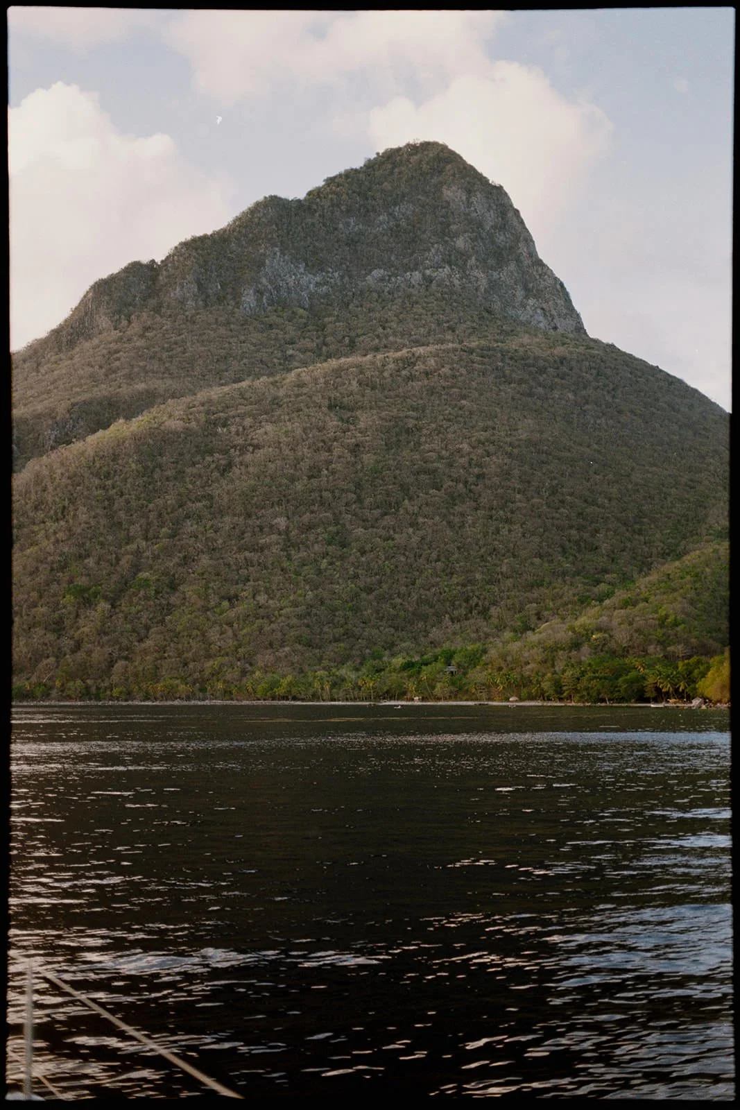 St. Lucia's Piton mountain peak rising above the calm water, seen from the catamaran during the wedding weekend sailing excursion