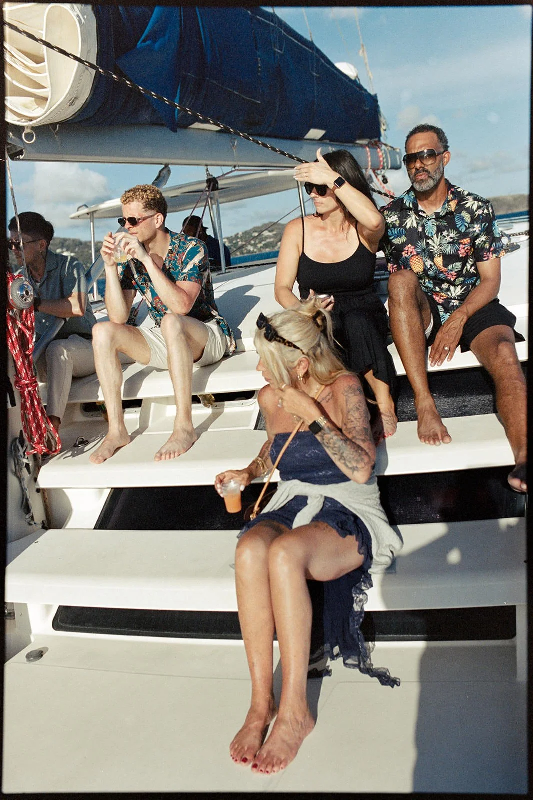 Wedding guests gathered on the catamaran's bow with drinks in hand, celebrating together during the sailing excursion