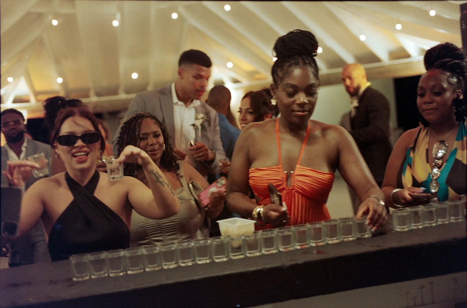 Wedding guests lined up doing shots together at the bar during the St. Lucia reception