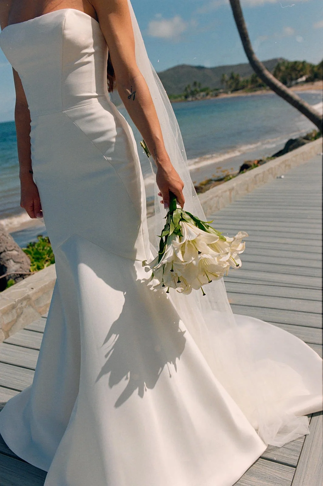 Bride in a fitted white gown walking along the beach in a dynamic pose at the St. Lucia wedding