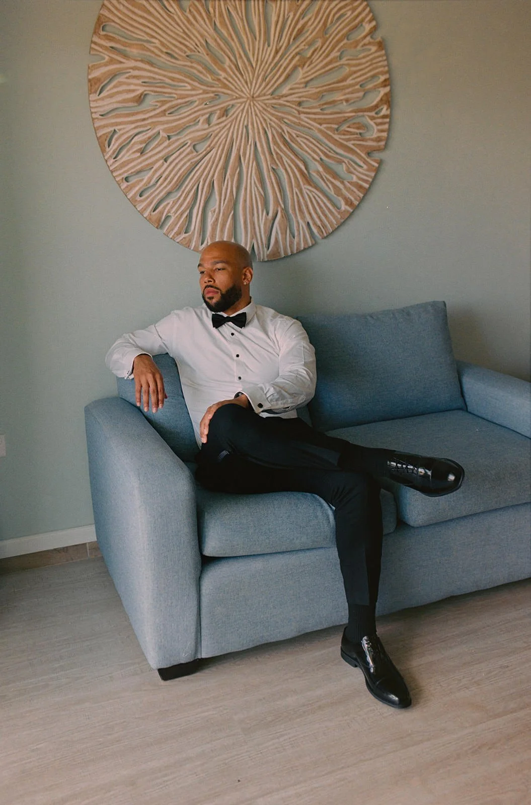 Groom relaxing on a blue chair, seated portrait at the St. Lucia wedding resort