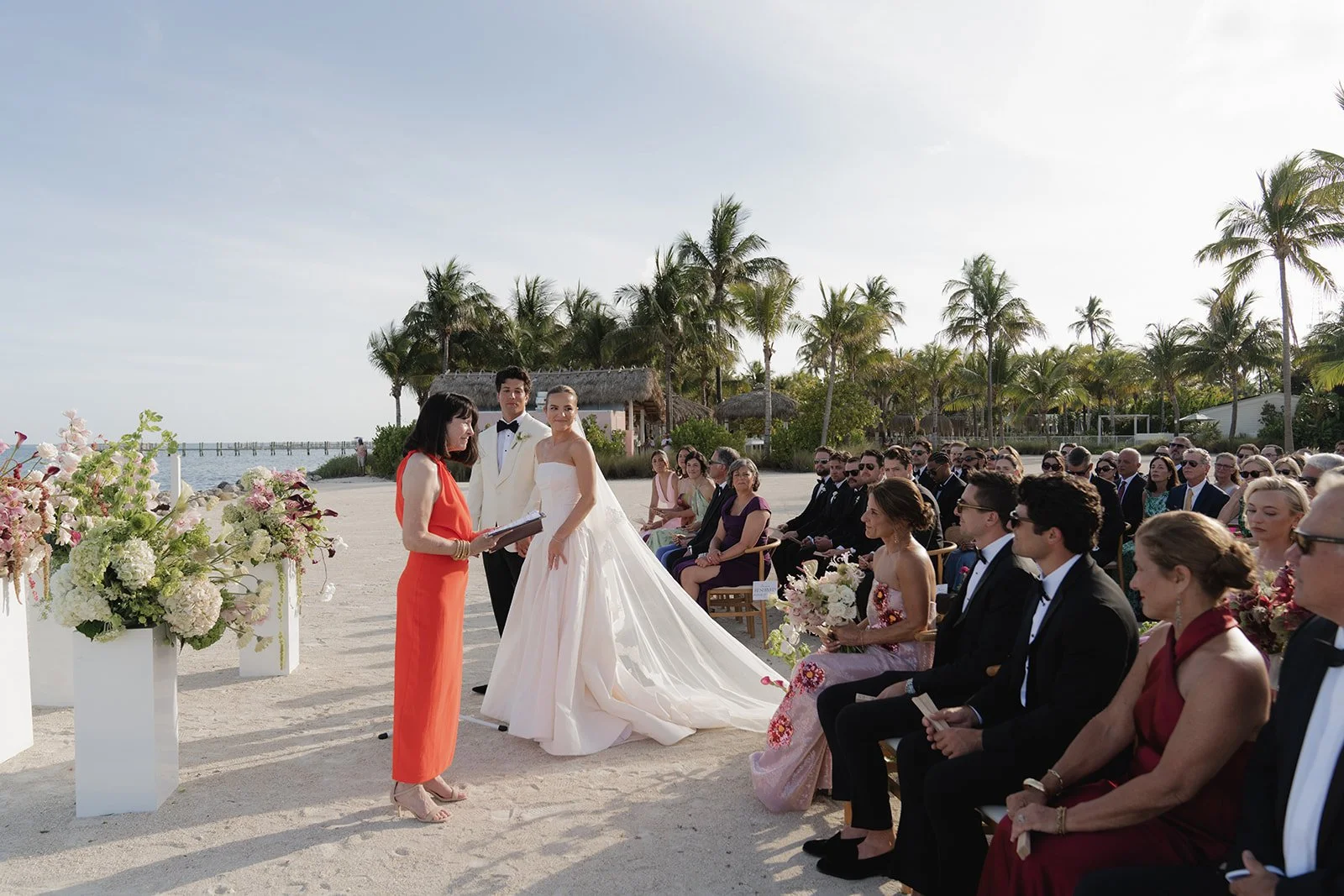 Guests watch the beachside wedding ceremony as the couple exchanges vows at the Islander Resort in Islamorada, Florida Keys