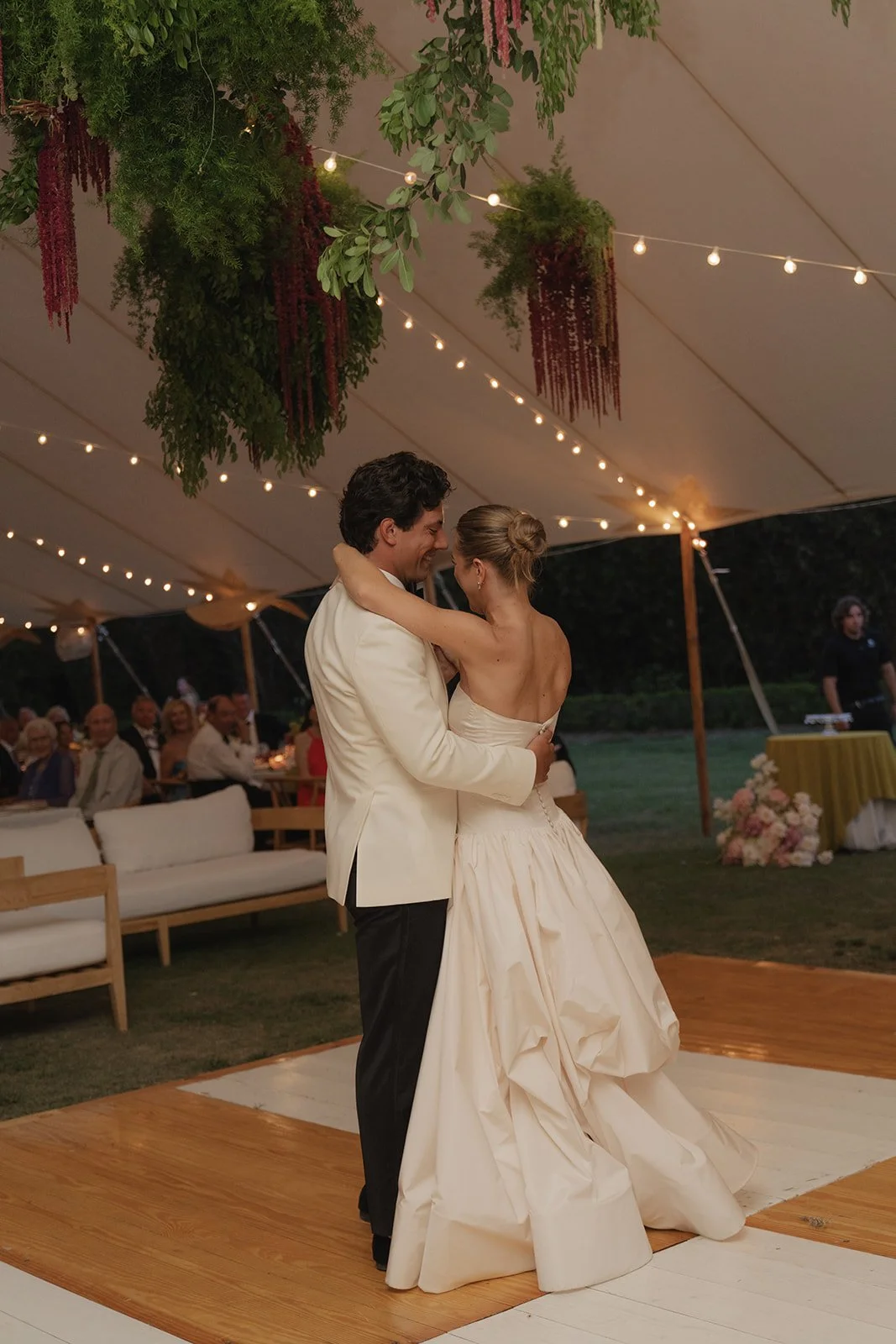 Bride and groom share their first dance under a string-lit tent at their Islamorada, Florida Keys destination wedding reception