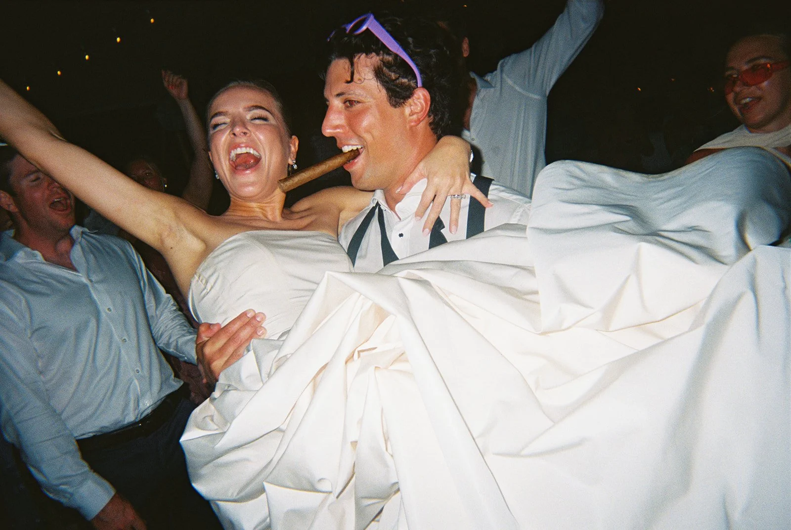Bride and groom laughing joyfully together at night surrounded by guests at this Islamorada, Florida Keys destination wedding