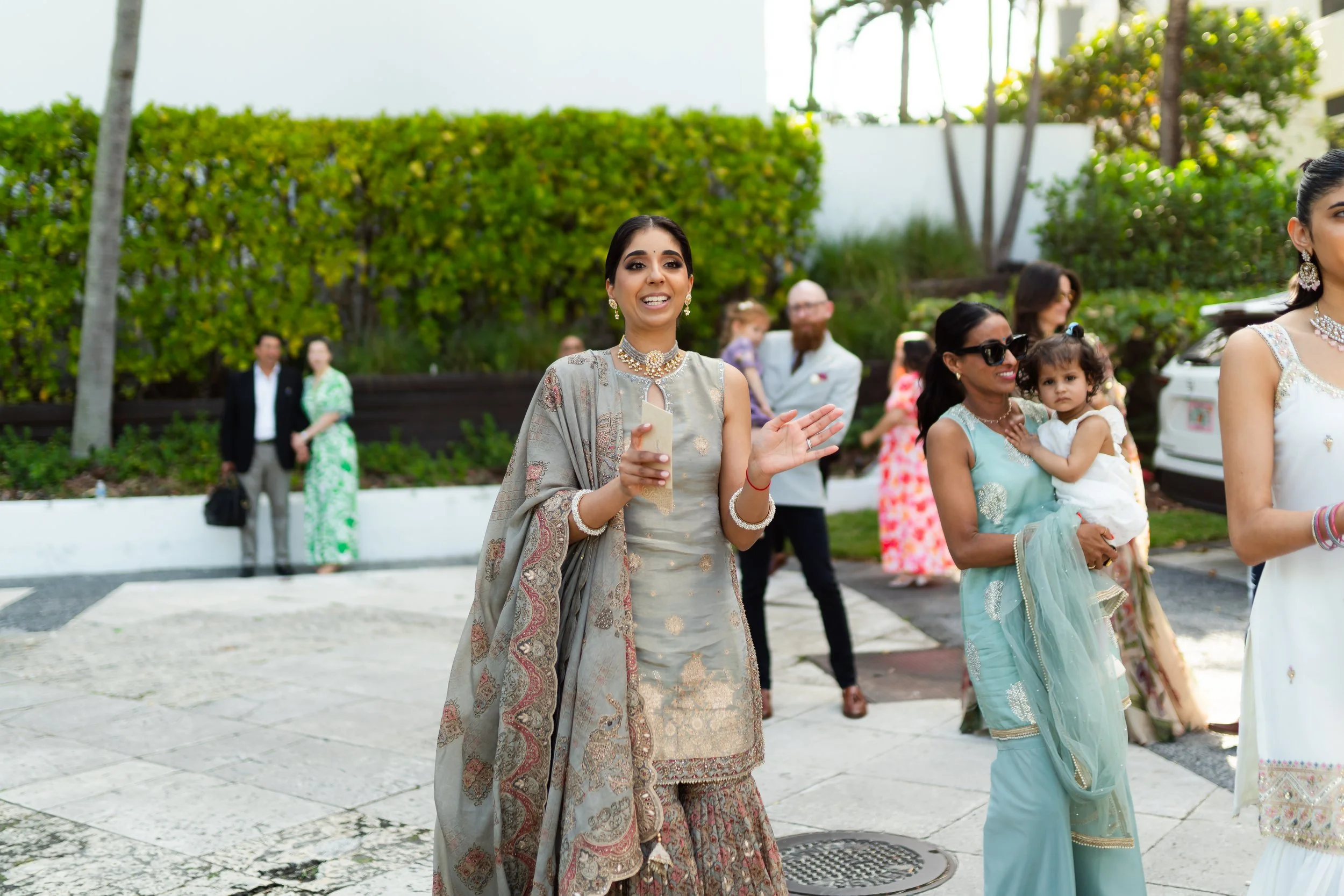People in traditional Indian attire attending an outdoor celebration or wedding