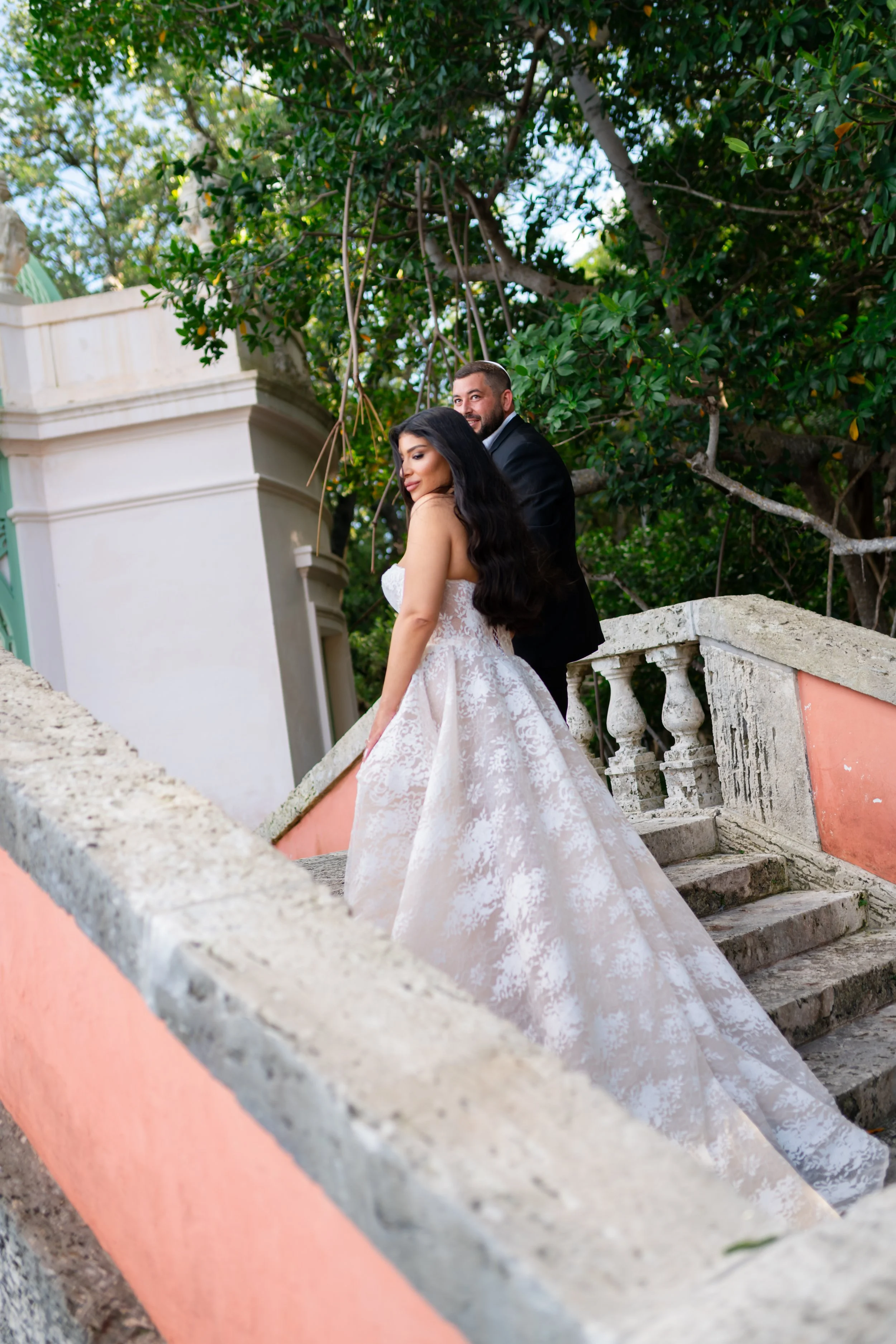 Bride and groom walking up the stairs at. Vizcaya Museum and Gardens Miami