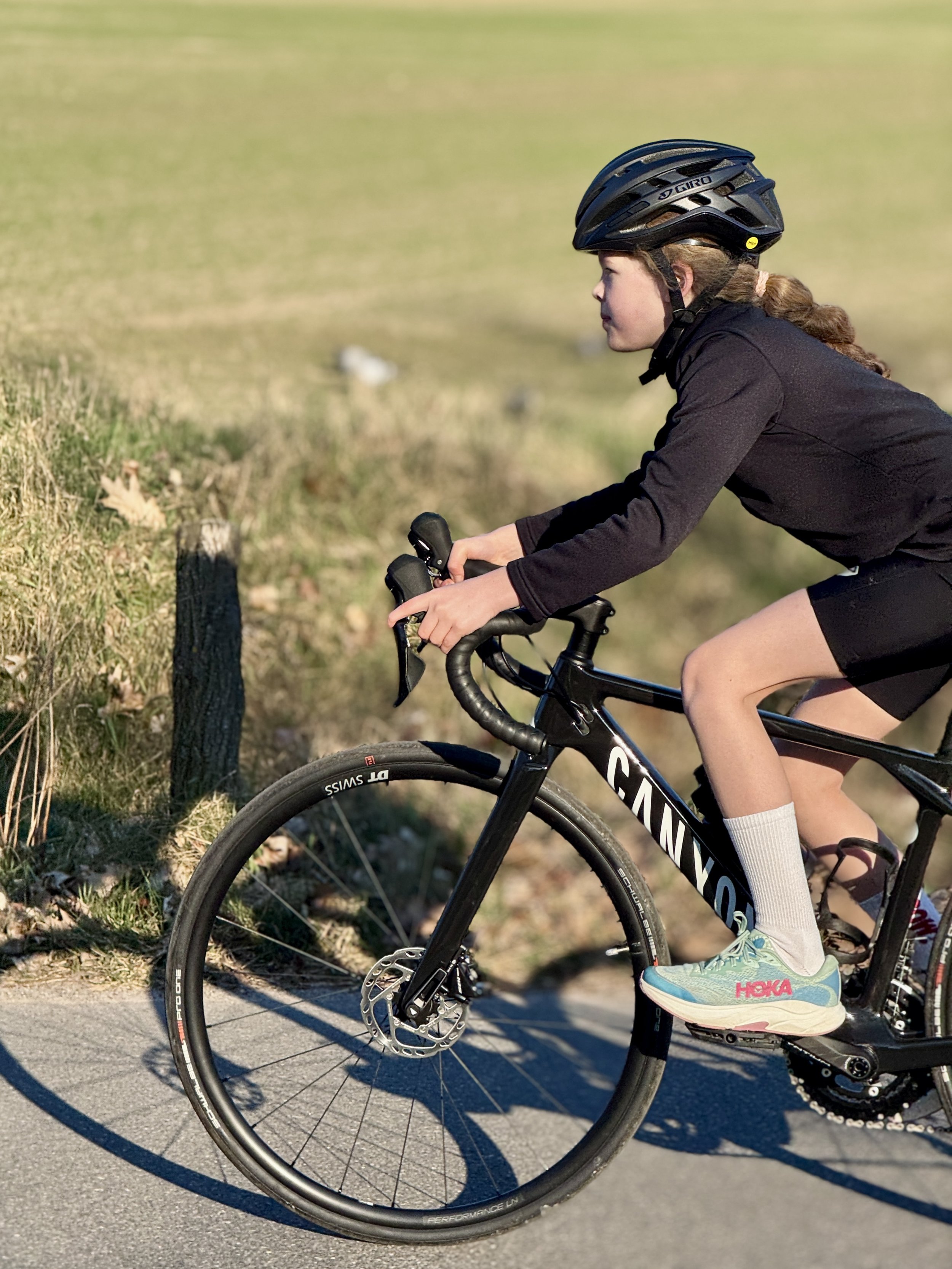 Detailaufnahme von Änden eines Kindes am Lenker eines Canyon Rennrades