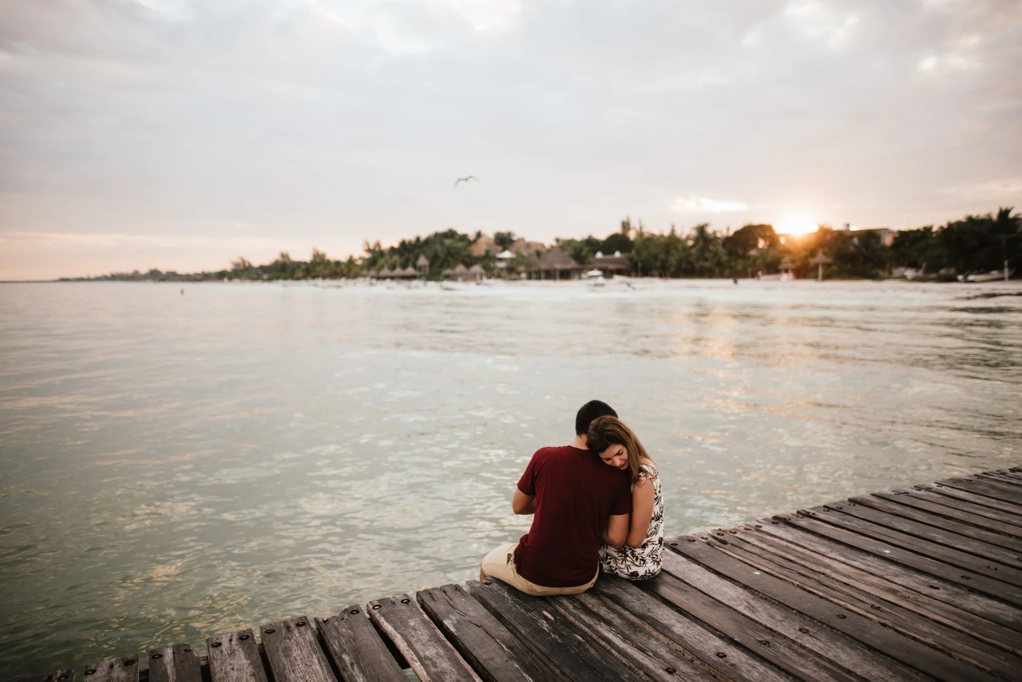pareja sentada en el muelle de holbox
