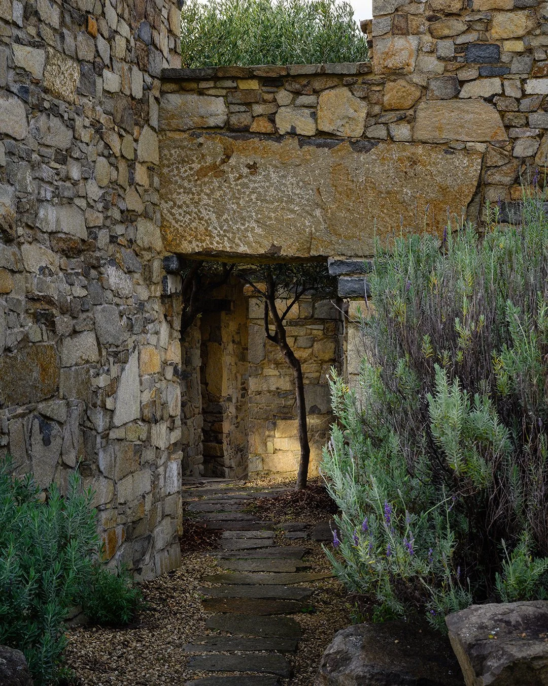 Stone pavilions and courtyard at Thalia Haven Tasmania — natural materials in a genuinely restorative coastal environment