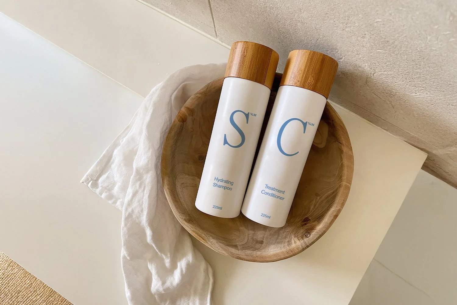 V&M SPA collection on stone surface — Balancing Shampoo, Treatment Conditioner, Body Wash and Lavender Bath Milk formulated with native Australian botanicals