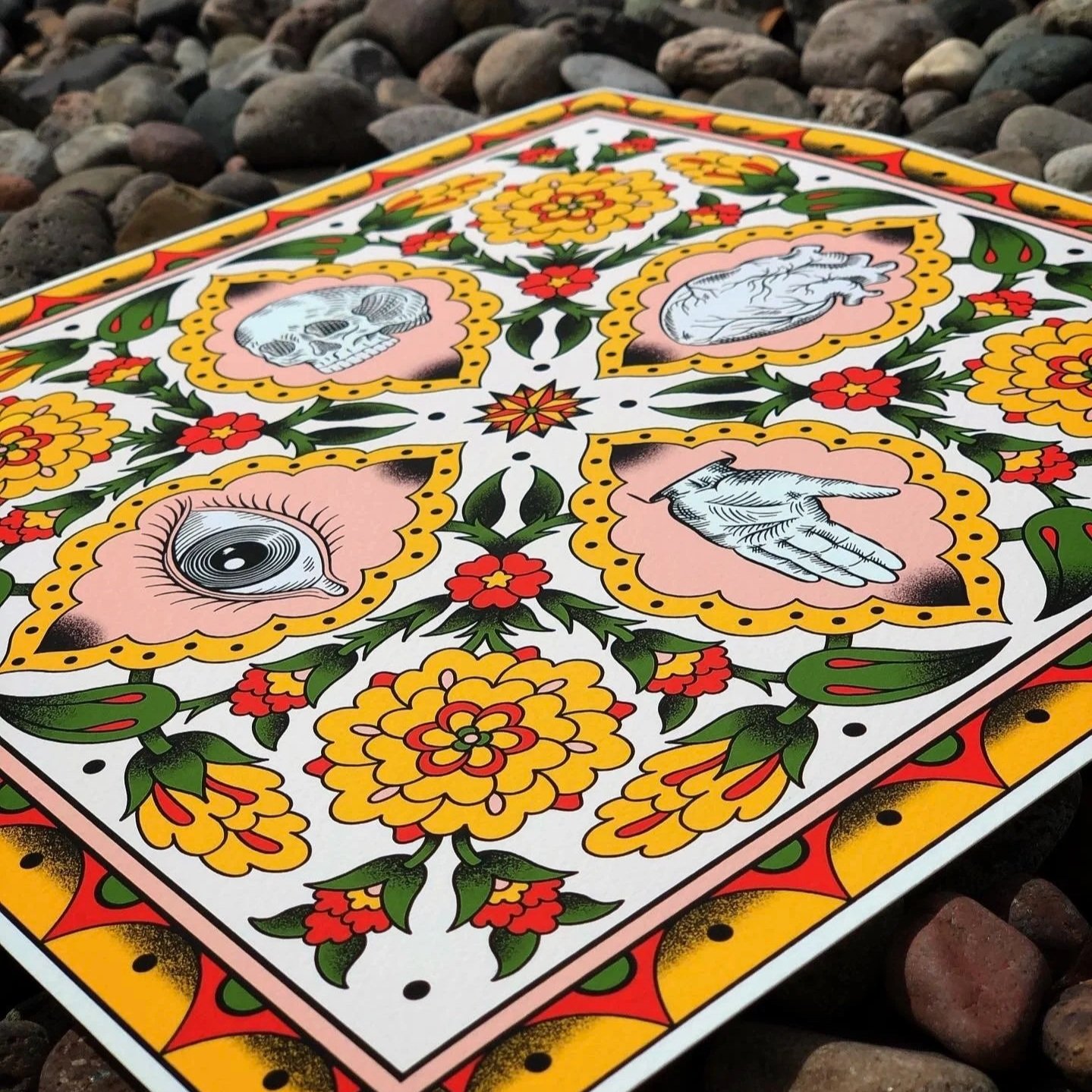 A colorful illustration on a card featuring symbols of the five senses: a skull, a heart, an eye, a hand, and a tongue, adorned with flowers and decorative patterns.