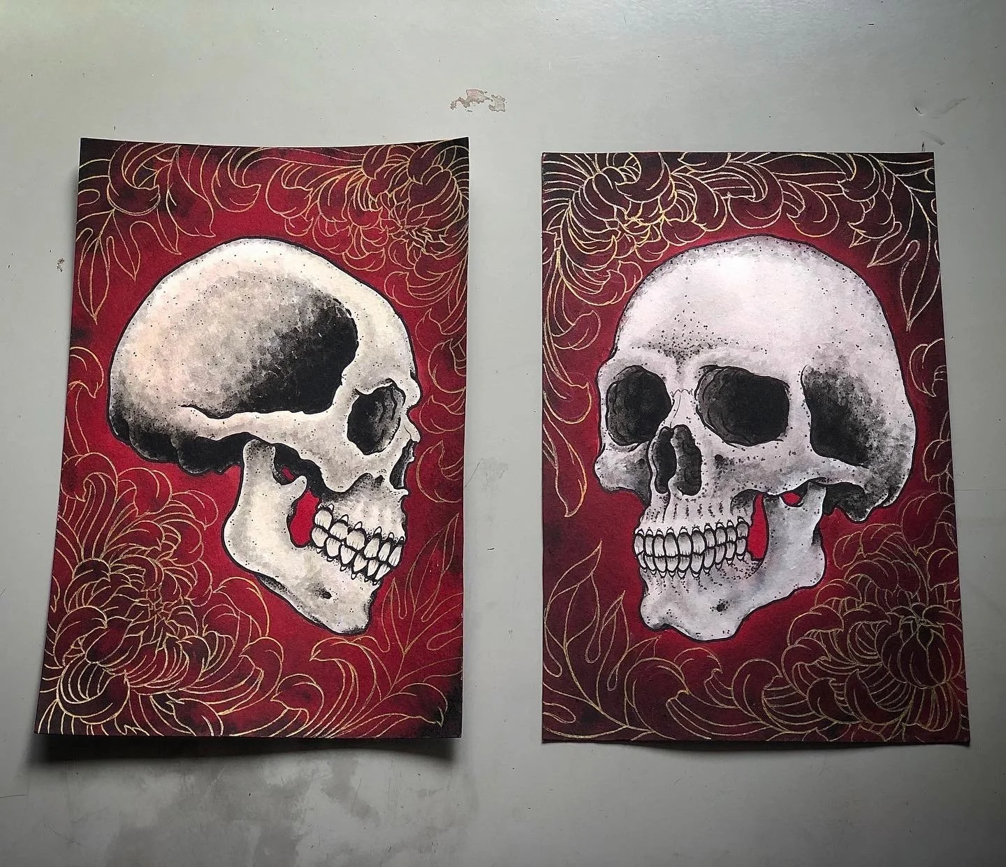 Two skull illustrations on red backgrounds with orange floral designs, the left skull in profile and the right skull facing forward.