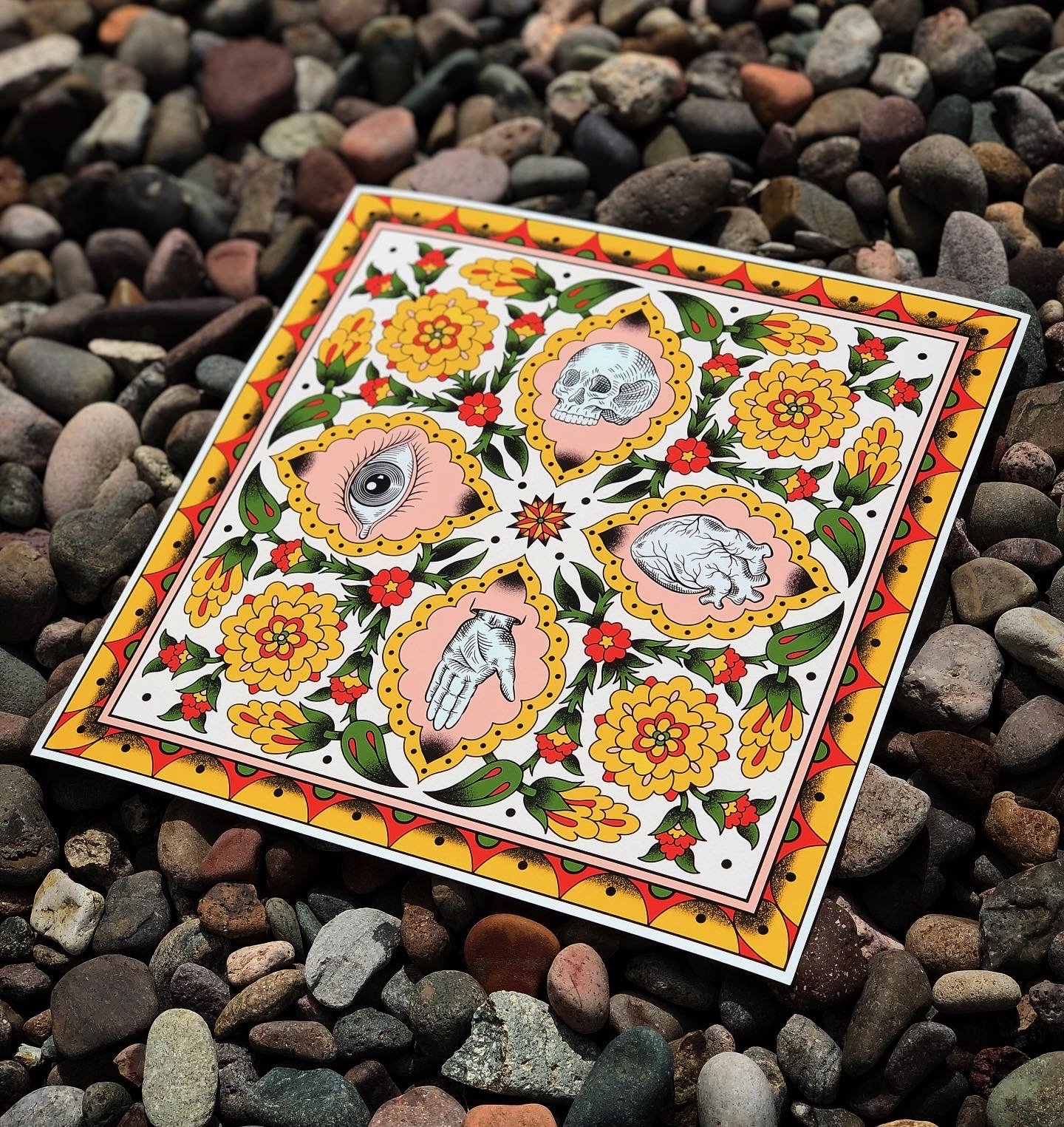 Decorative card with floral and skull illustrations, featuring a single eye, brain, skull, and hand images, set on rocky ground.