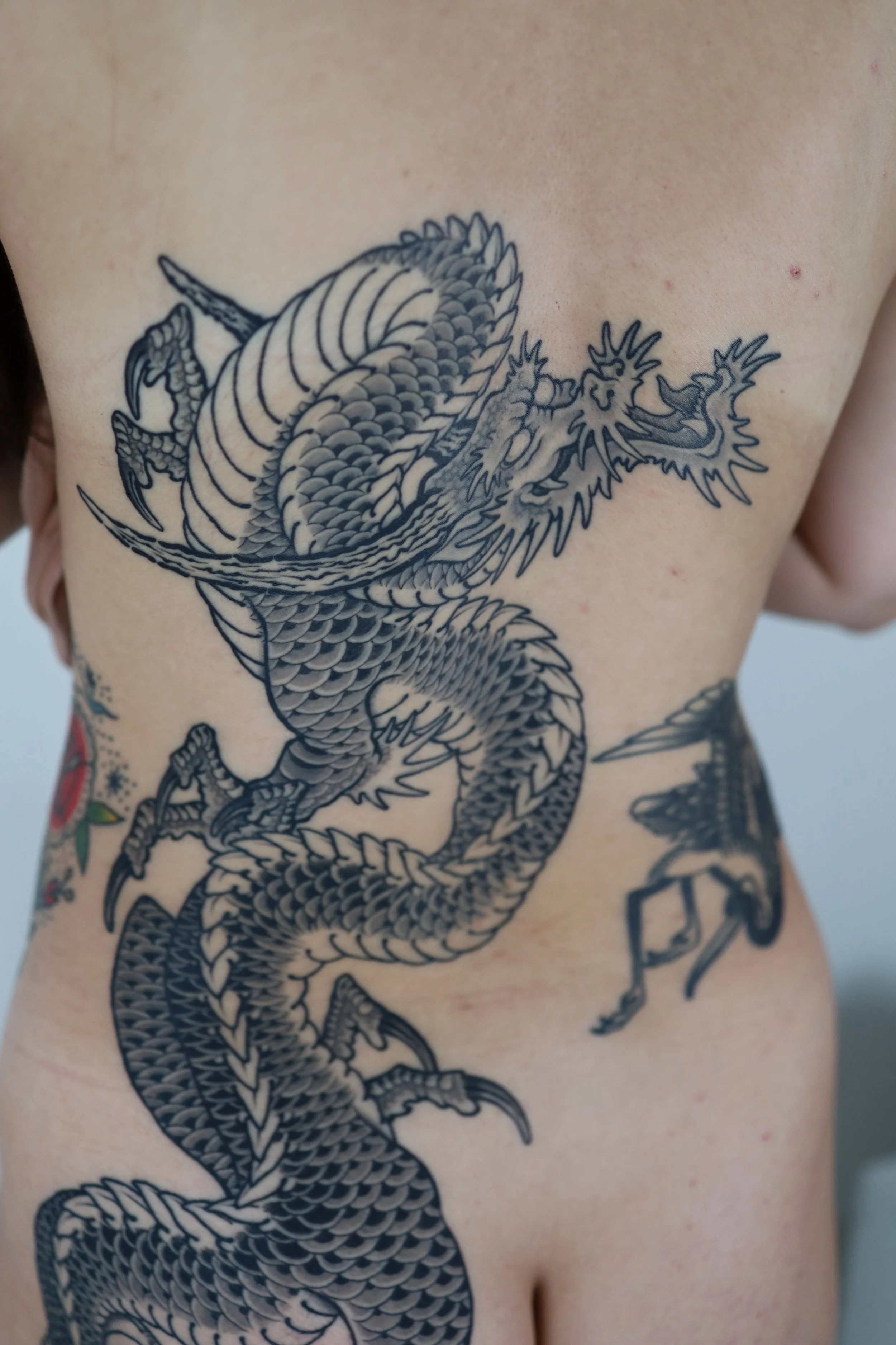 Tattoo of a detailed Chinese dragon on a person's side.