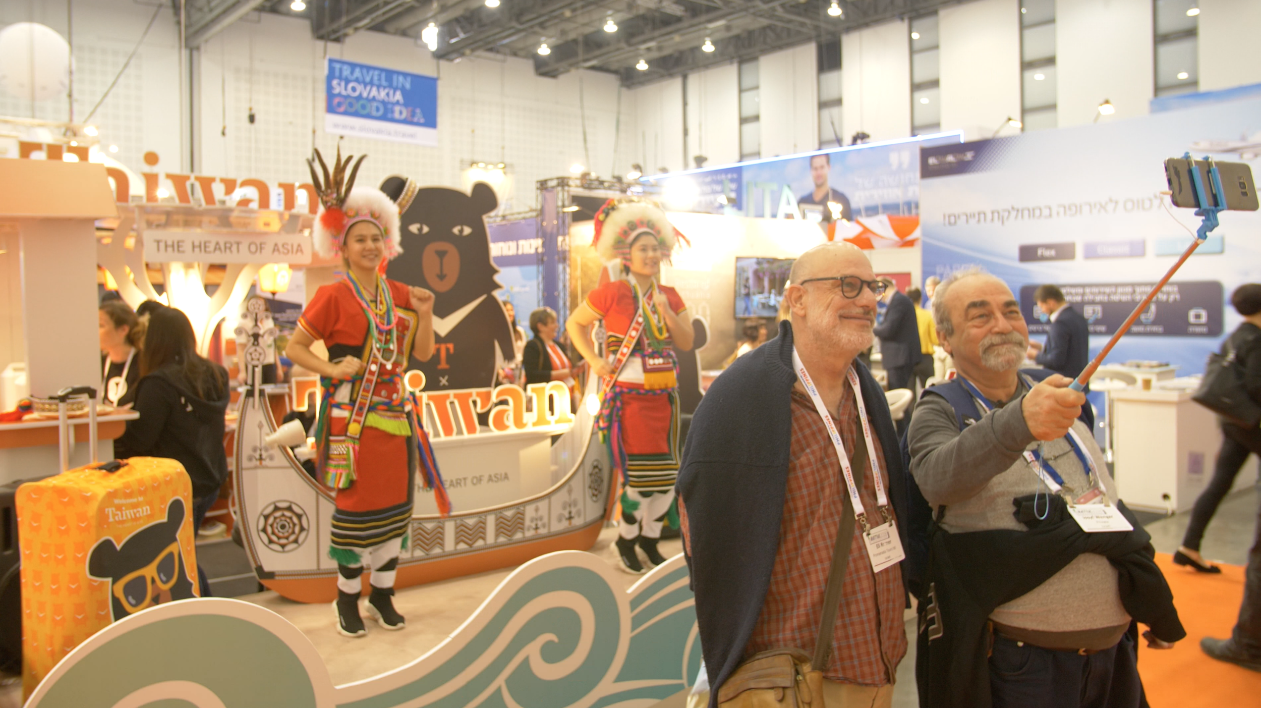 Guests take a selfie in front of Taiwanese aboriginal dancers.png
