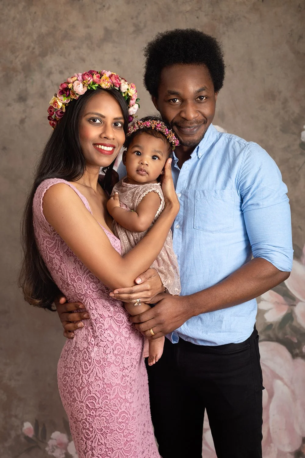 Mum, dad and their baby daughter posing for a family photo during their family shoot in Leeds