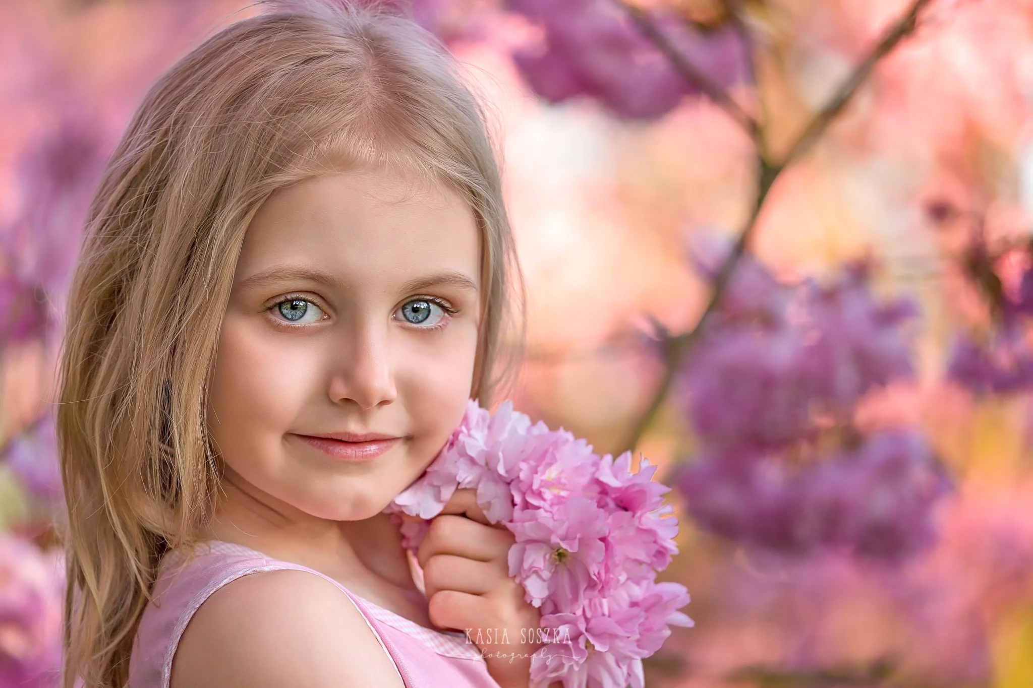 Leeds child photography Bradford child session York children photography: pretty little blond girl in a pink dress holding pink cherry blossoms