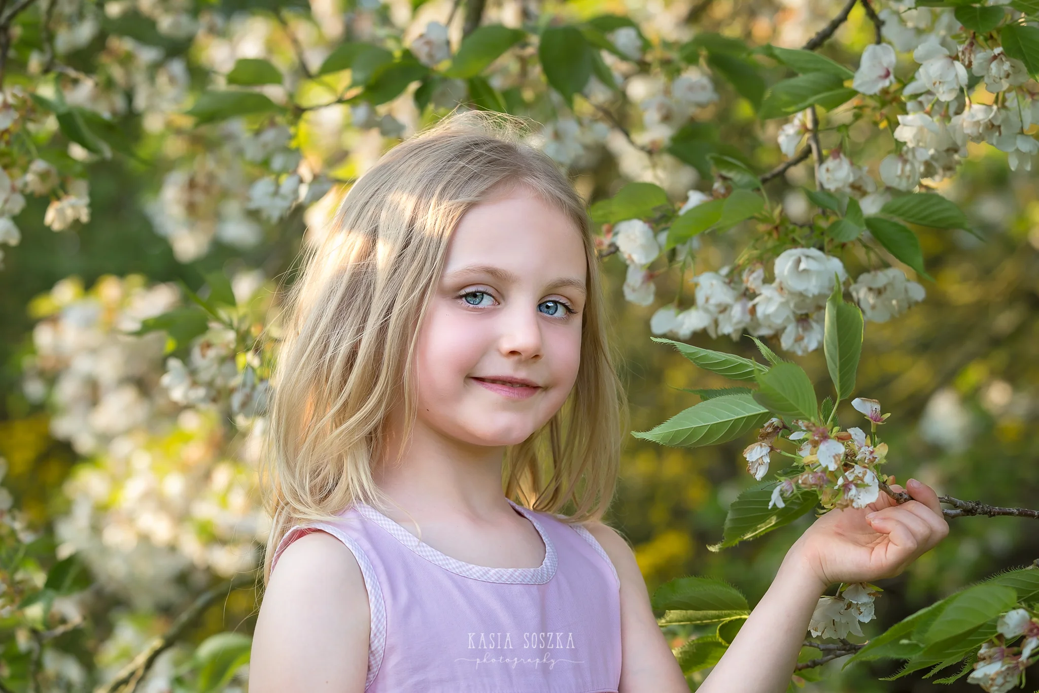 Leeds child photography Bradford child session York children photography: pretty little blond girl in a pink dress holding a branch of a blossoming apple tree