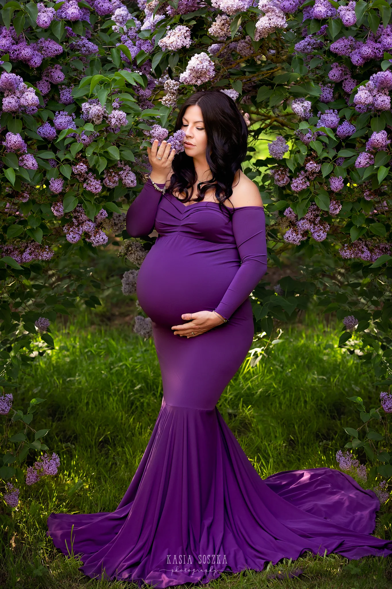 Leeds maternity photography Leeds Bradford York Harrogate maternity photographer:stunning pregnant woman with dark hair in a long purple dress smelling lilac flowers.