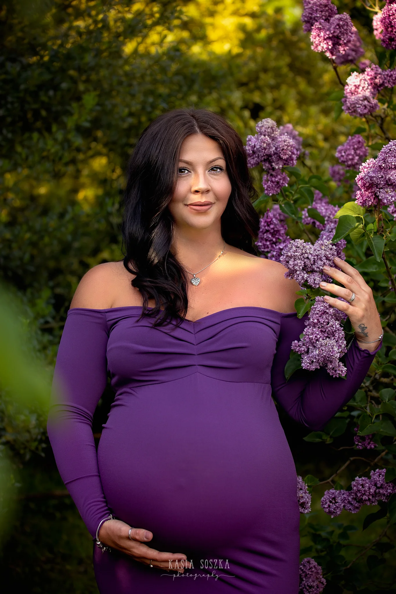 Leeds maternity photography Leeds Bradford York Harrogate maternity photographer: portarit of a beautiful pregnant woman wearing long purple dress and holding a branch of lilac flowers