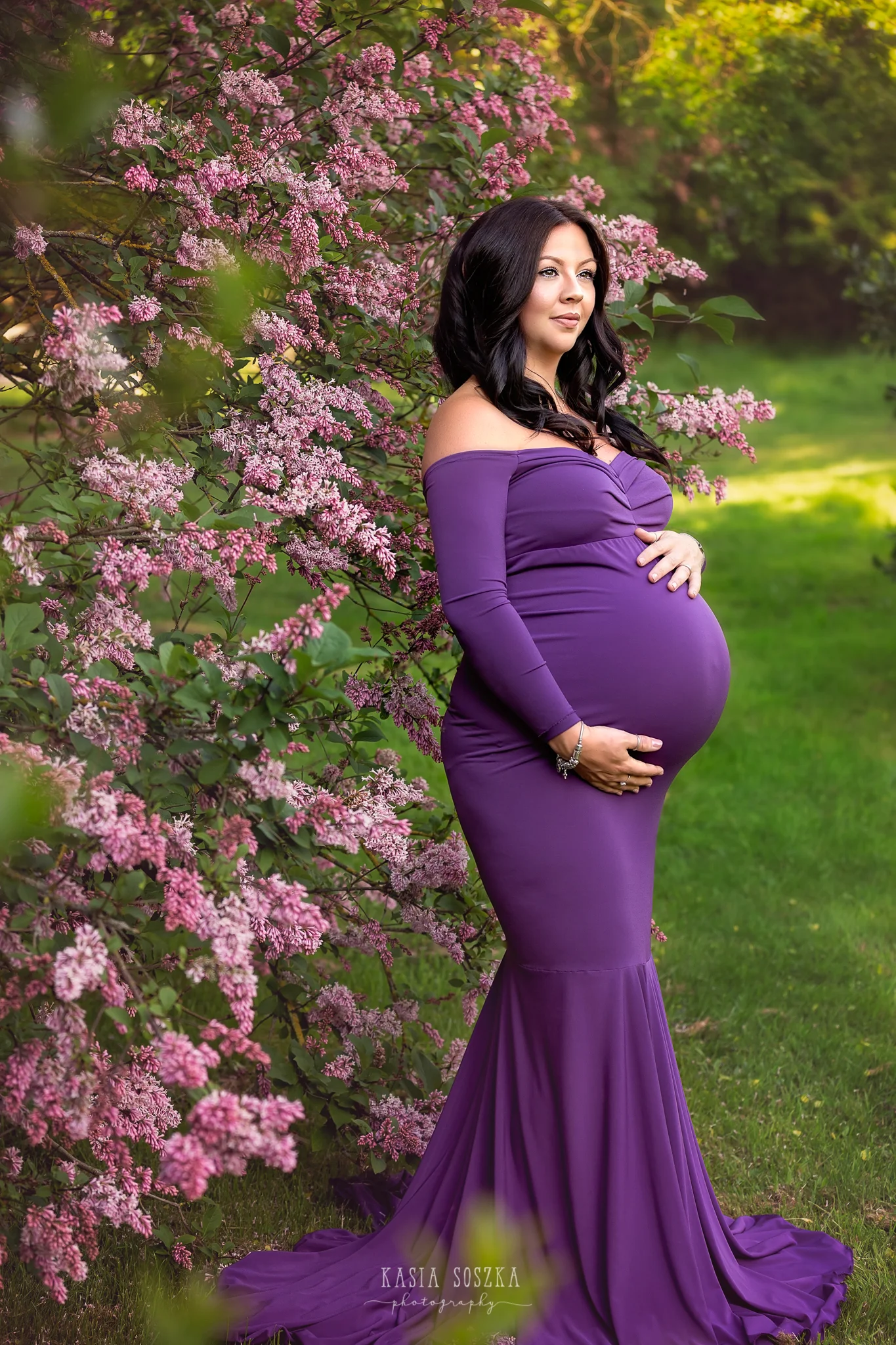 Leeds maternity photography Leeds Bradford York Harrogate maternity photographer:stunning pregnant woman in a long purple dress posing for maternity photo by blossoming tree