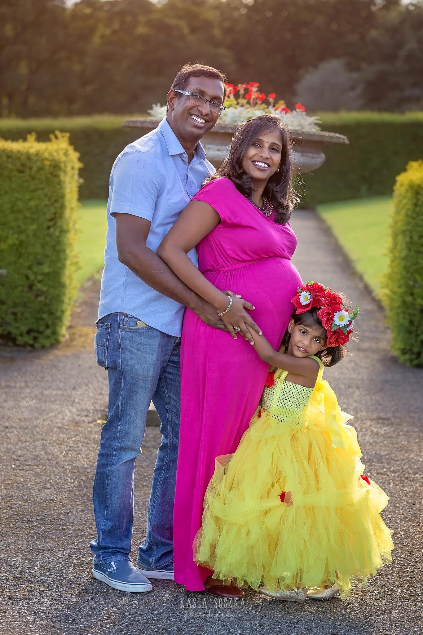 Family photography Leeds, maternity photography Leeds: beautiful young family waiting for a new family member posing for a family photo in a beautiful garden