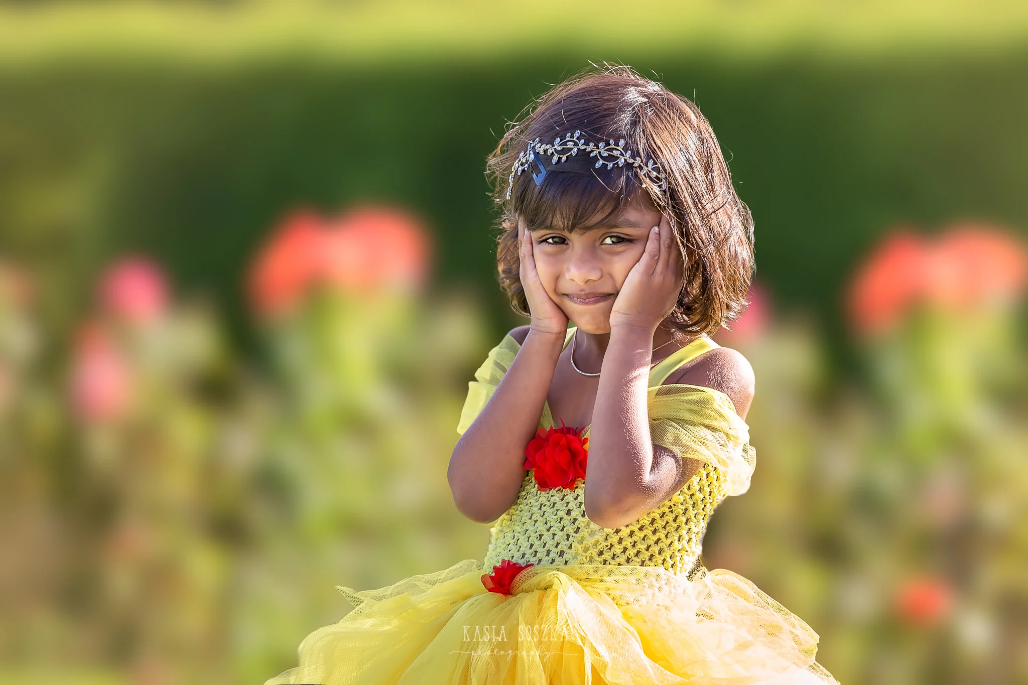 Child photography Leeds, child outdoor princess session Leeds, Yorkshire: beautiful little girl in a yellow princess dress posing for a photo in a garden 