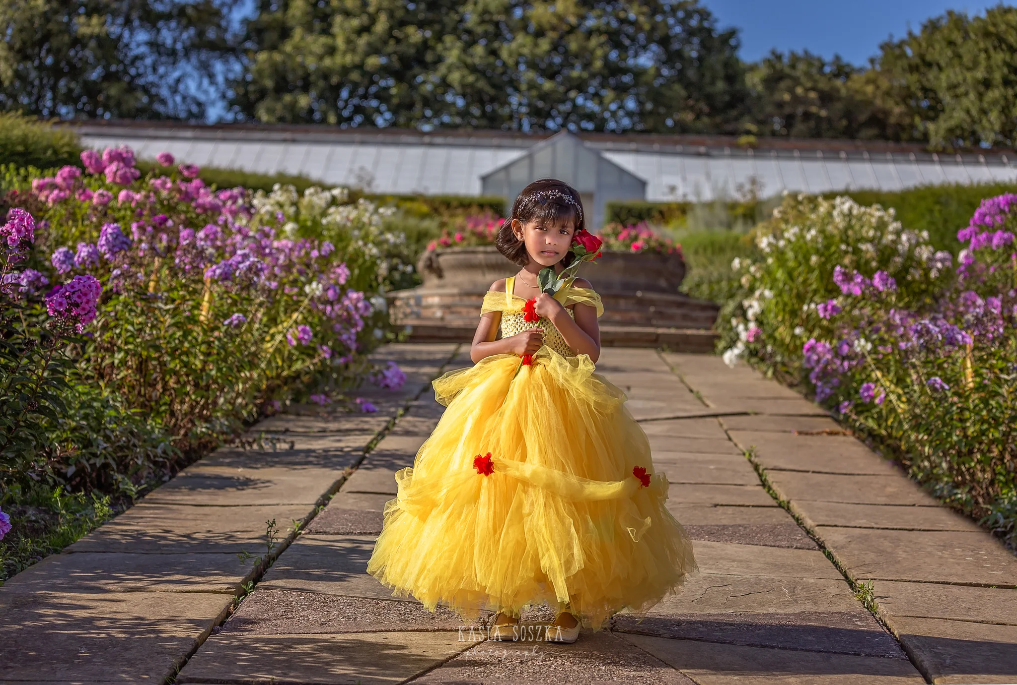 Child photography Leeds, child outdoor princess session Leeds, Yorkshire: beautiful little girl in a yellow princess dress posing for a photo in a garden