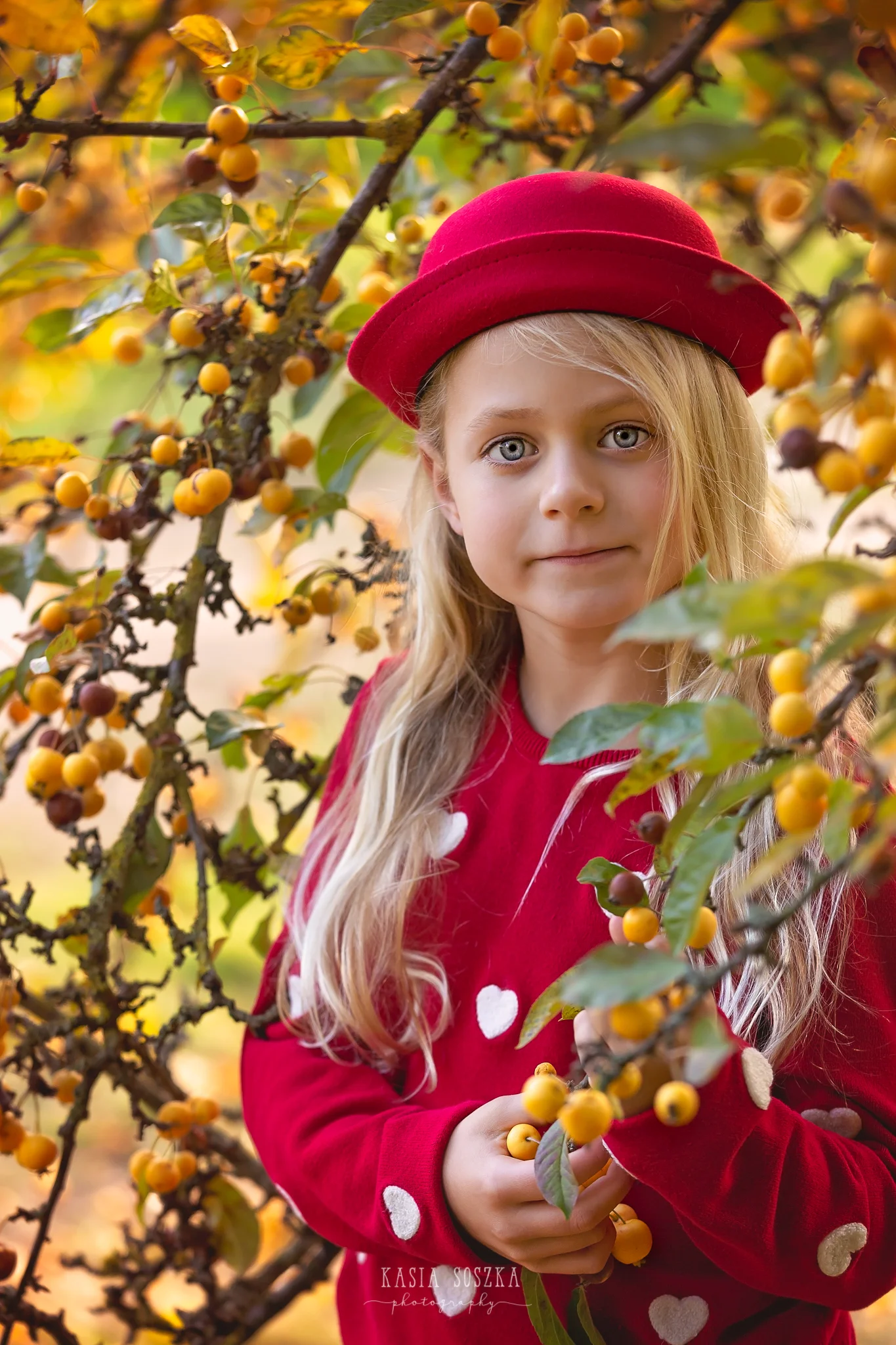 Children photography, child photographer Leeds, York, Bradford, Harrogate: pretty blond girl holding a berry tree branch