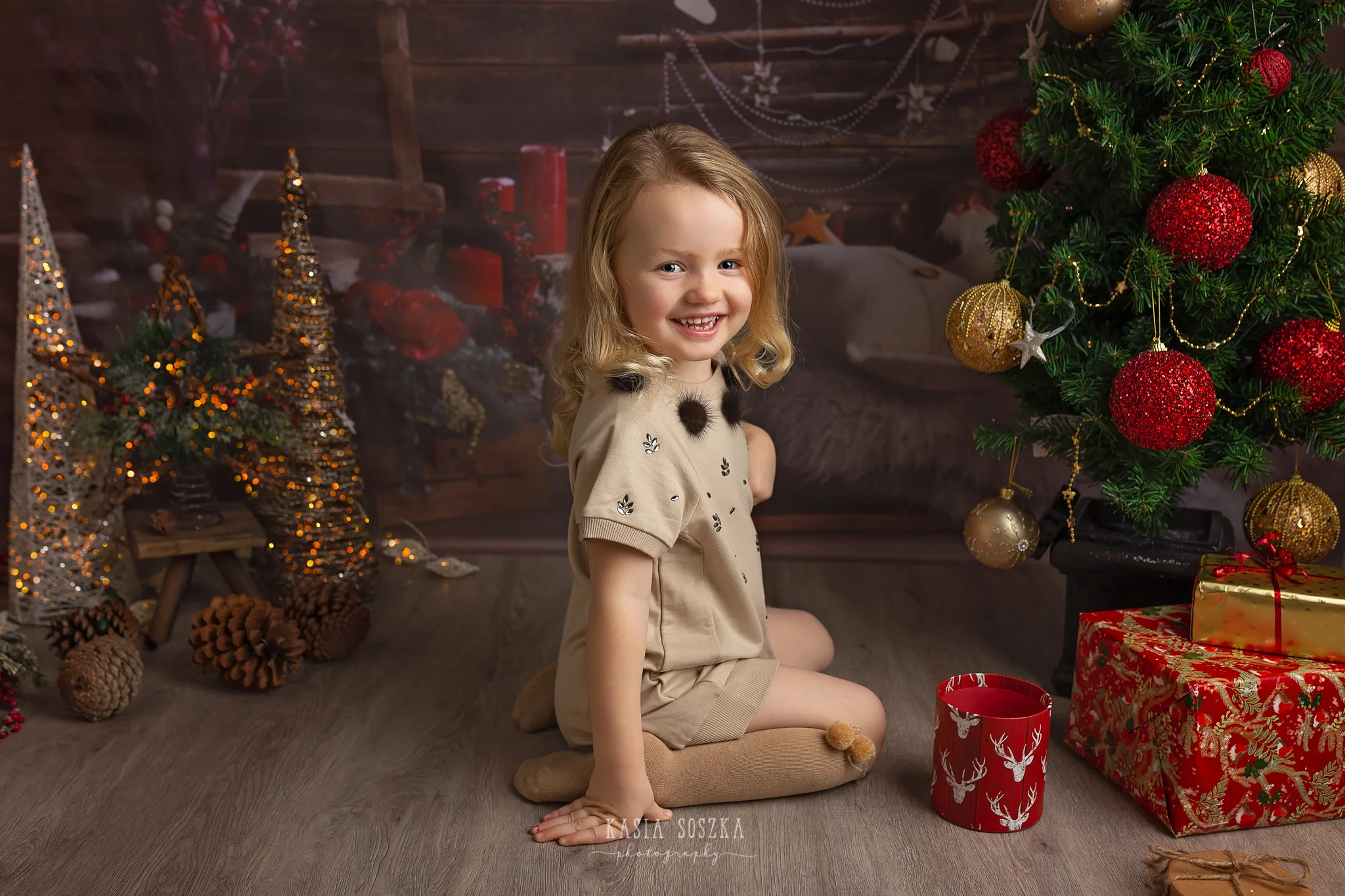 Child photographer Leeds, York, Bradford, Harrogate. Christmas Mini Sessions 2018 Leeds: beautiful little girl sitting by Christmas tree.