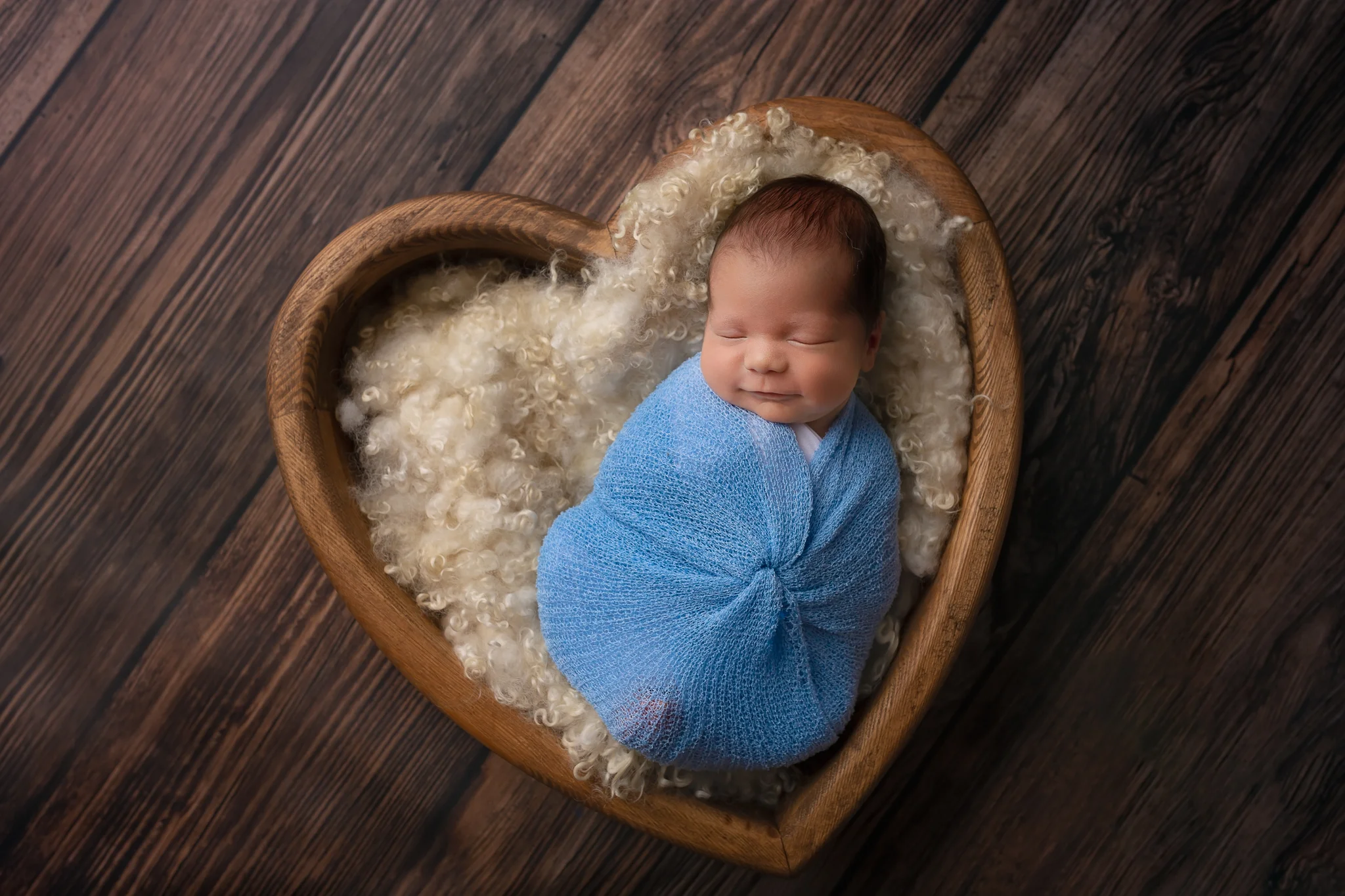 Newborn photographer Leeds, York, Bradford, Harrogate, Wakefield: newborn baby sleeping in a heart shaped bowl during his newborn photoshoot in Leeds, West Yorkshire