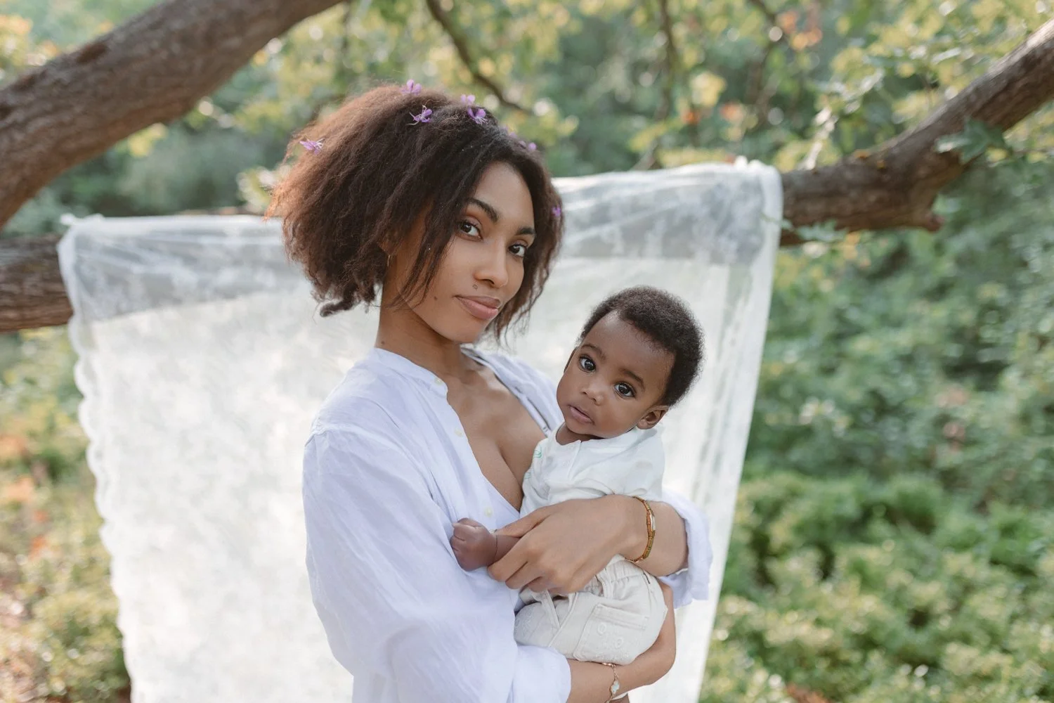 A young mother holding her baby son on a sunny summer evening in Leeds