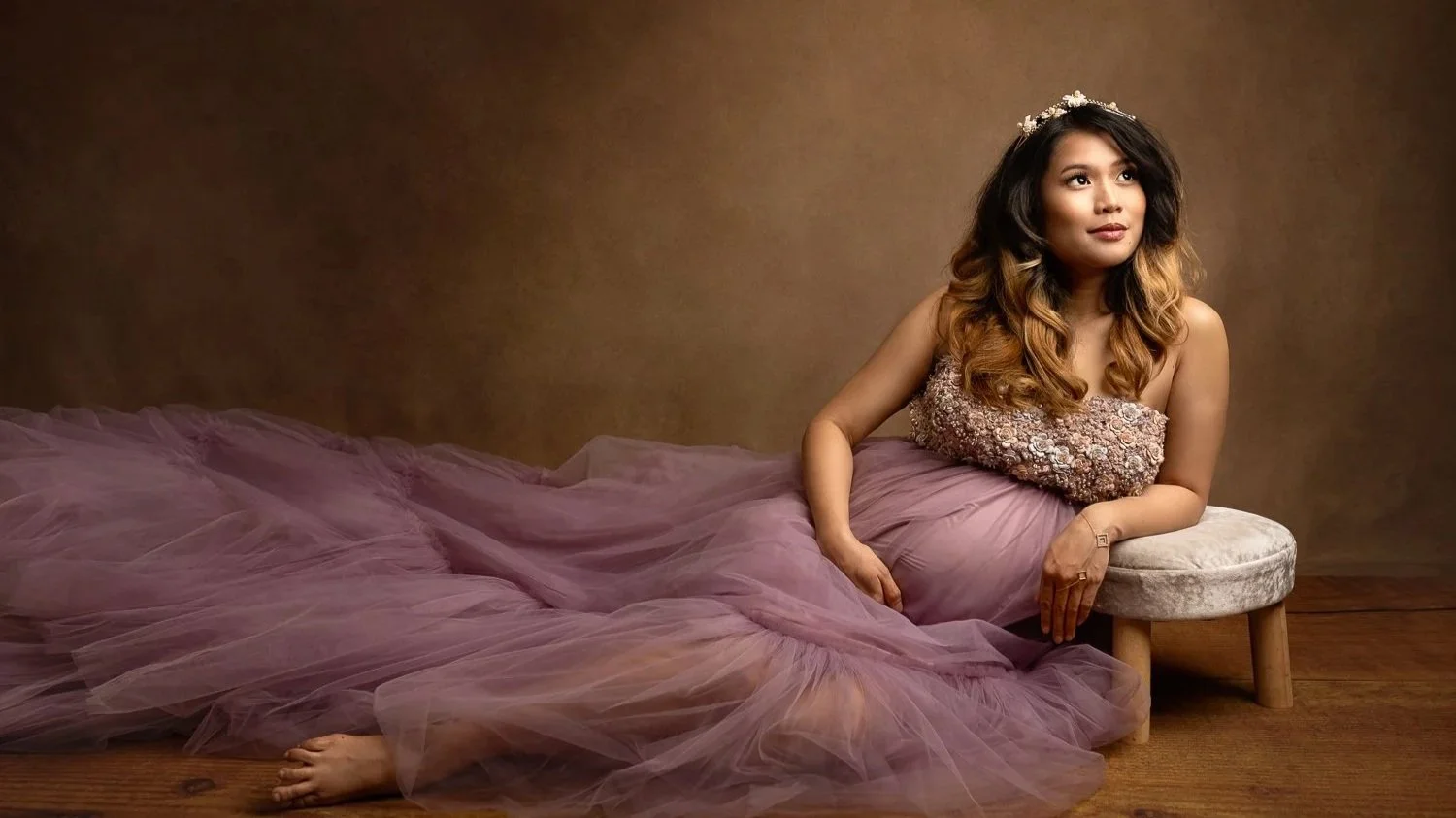 Leeds maternity photography: beautiful pregnant woman in a couture purple gown sitting on the floor posing for her maternity photo during a photoshoot in Leeds